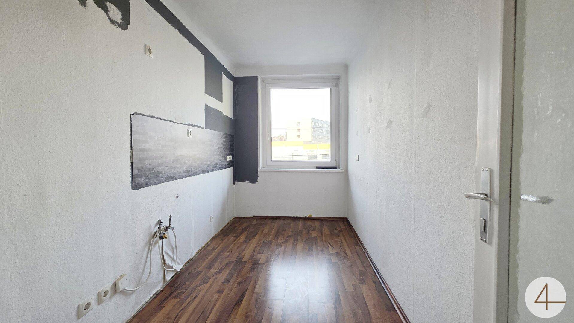 Kleines Zimmer mit Laminatboden und Fenster, ideal als Kinderzimmer oder Arbeitsbereich.