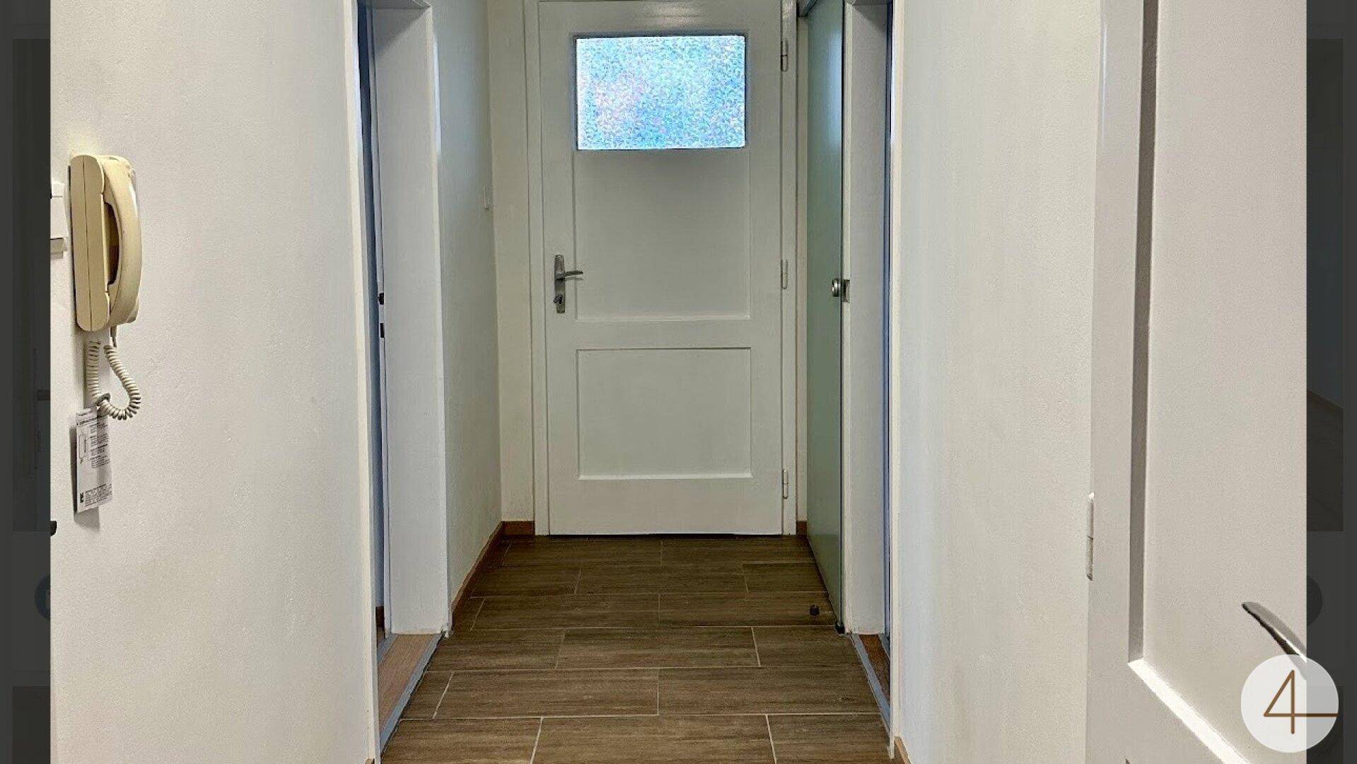 Heller Flur mit Laminatboden und weißen Türen, der zu verschiedenen Räumen führt.