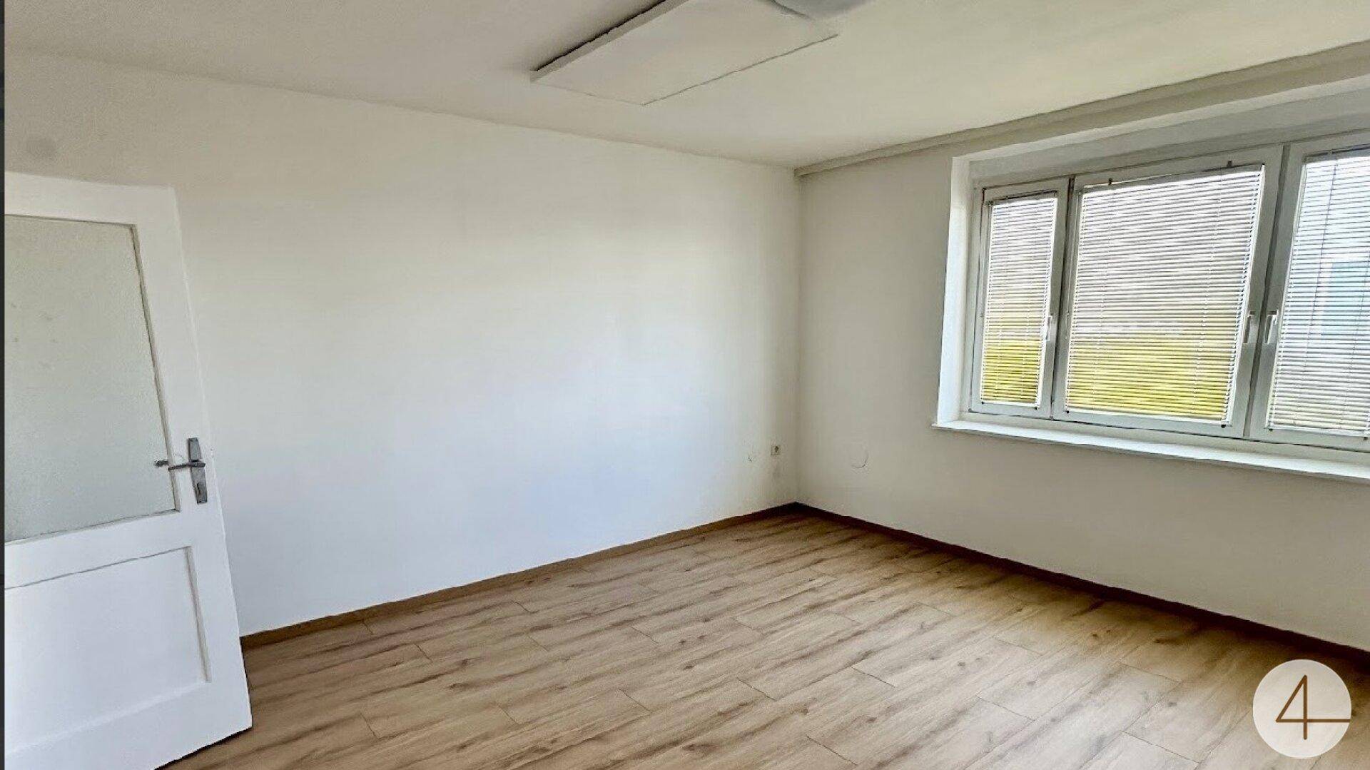 Freundliches Zimmer mit Laminatboden und Fenster, das eine angenehme Atmosphäre schafft.