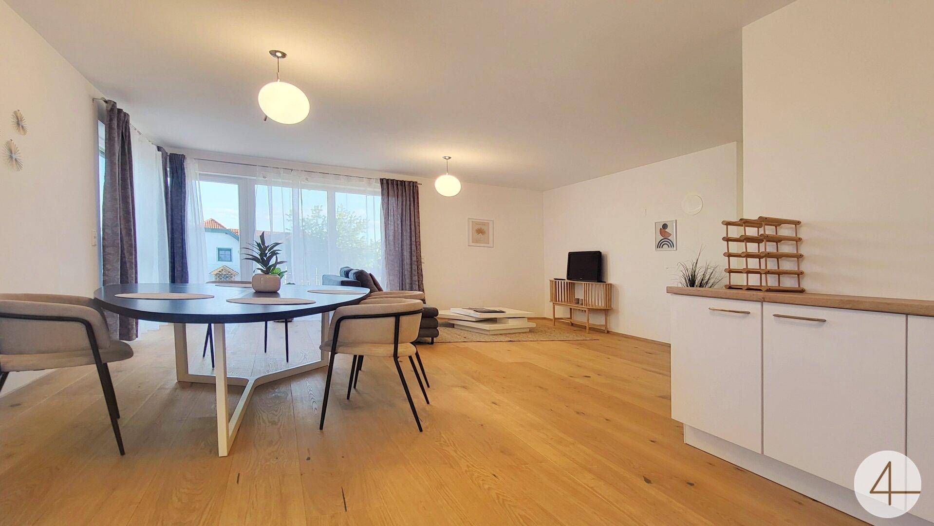 Geräumiger Wohn-Essbereich mit offener Küche und Zugang zur Terrasse.
