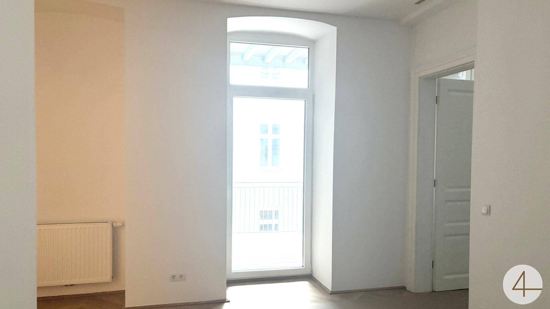 Heller Raum mit großem Fenster und Heizkörper, bietet viel Tageslicht.