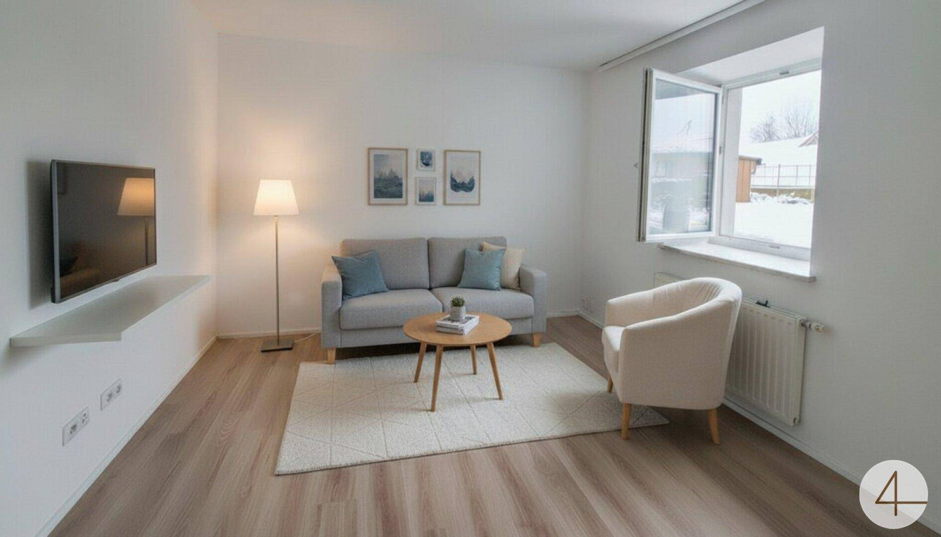 Helles Wohnzimmer mit Sofa, Sessel, Fernseher und Laminatboden, gut beleuchtet durch ein Fenster.