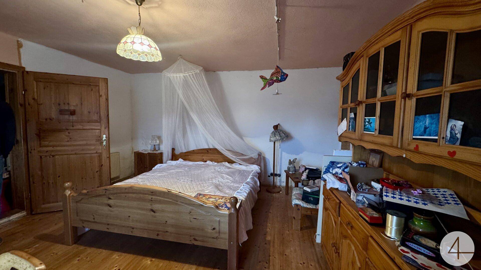 Einfaches Schlafzimmer mit Holzbett, Holzschrank und Holzboden in traditionellem Stil.