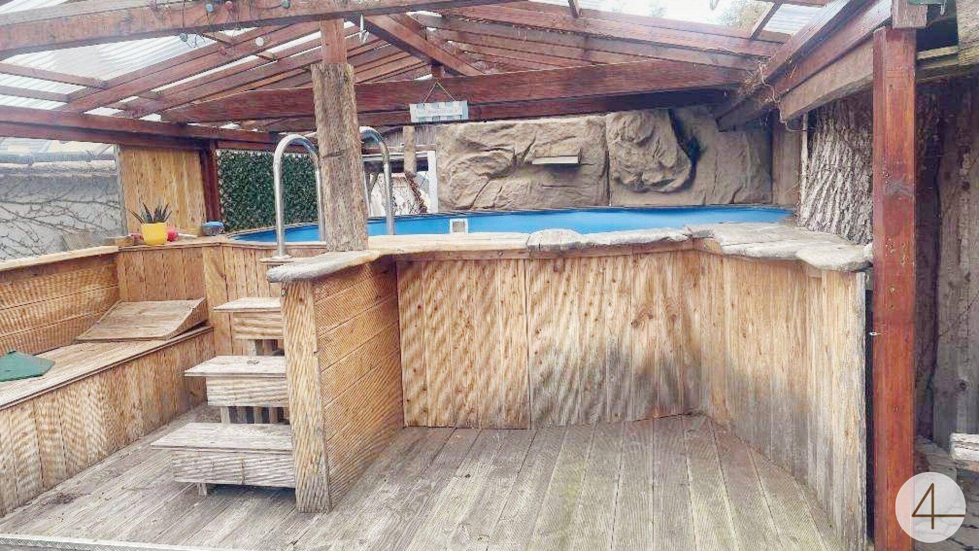 Überdachter Außenpoolbereich mit Holzverkleidung, Treppe und einer rustikalen Gestaltung.