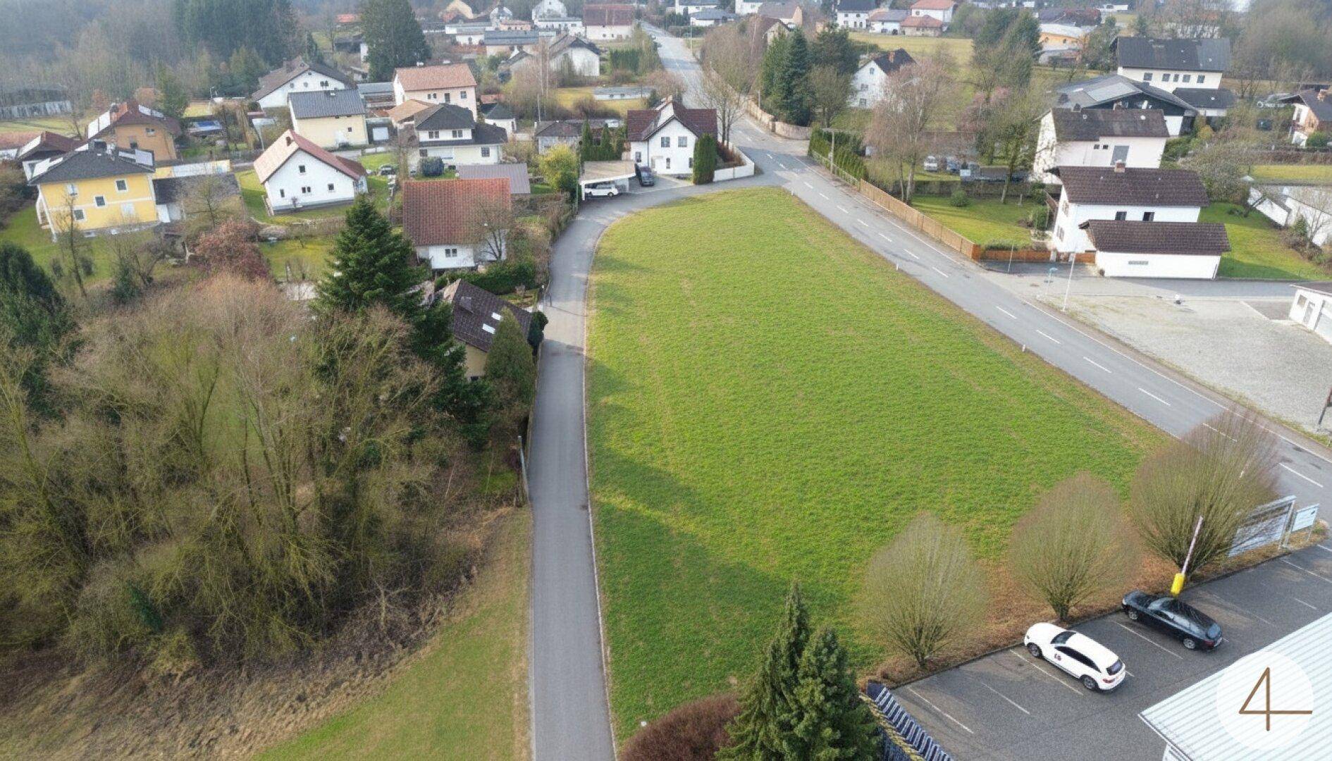 Weitwinkel-Luftaufnahme eines ausgedehnten grünen Grundstücks und der umliegenden Wohnsiedlung.