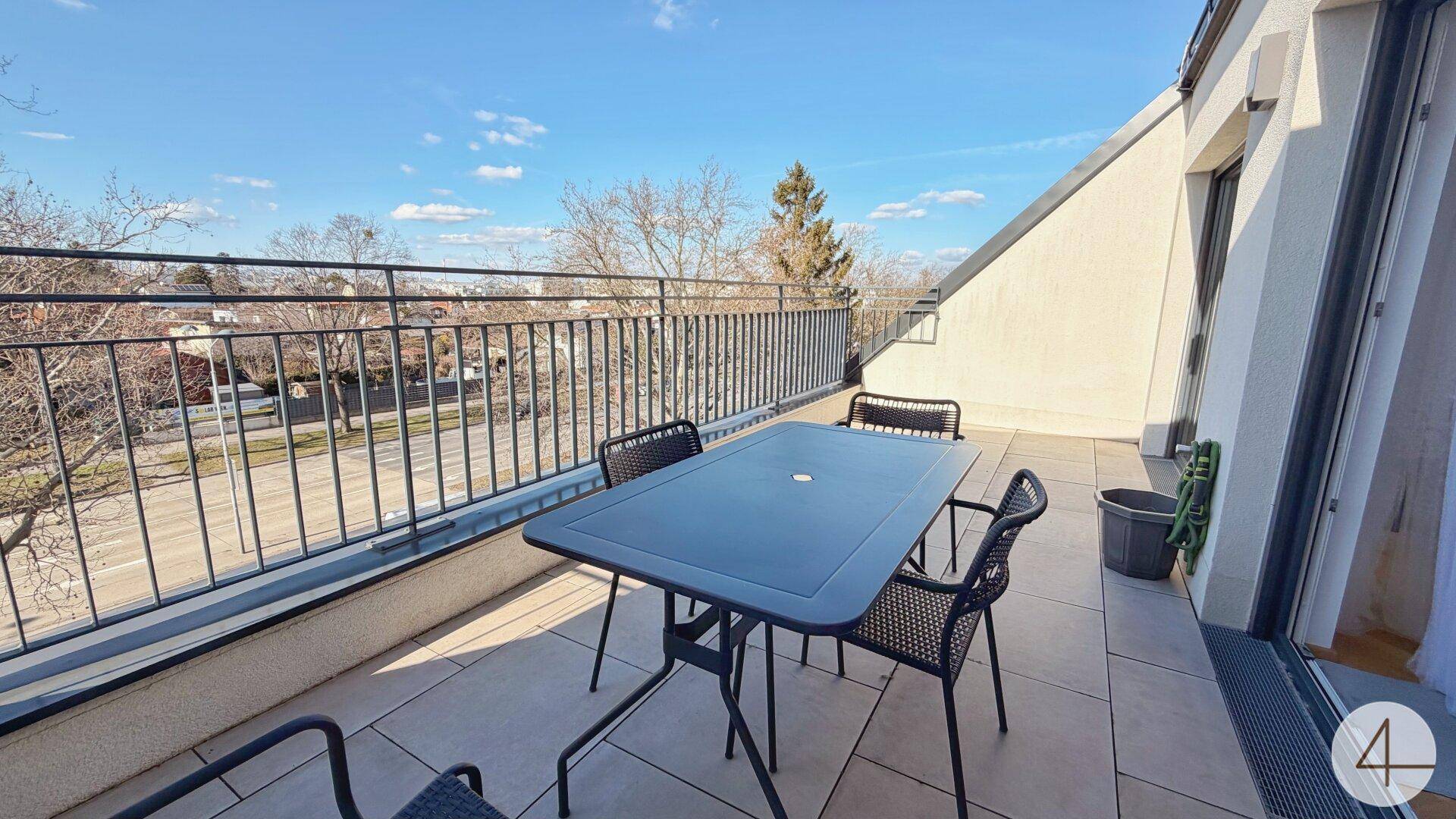 Große Dachterrasse mit Fliesenboden, Gartenmöbeln und weitem Blick über die Umgebung.