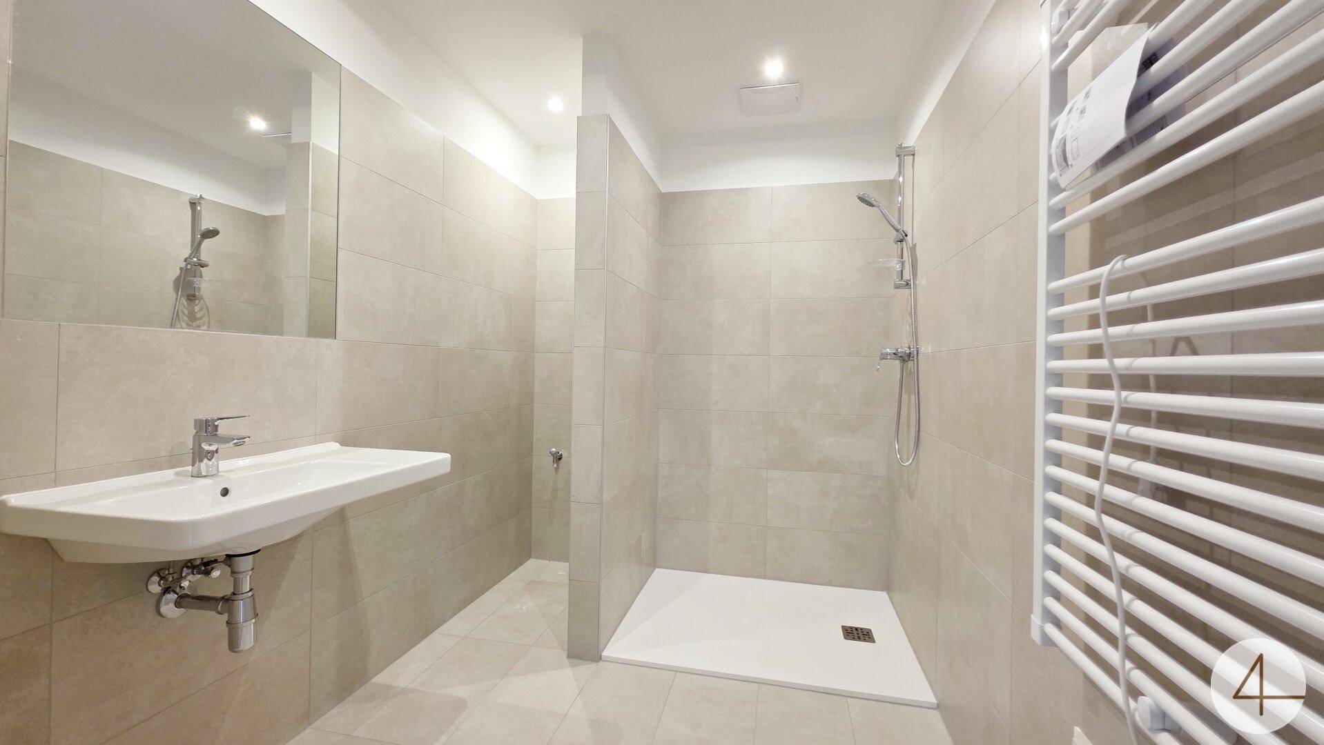 Modernes Badezimmer mit begehbarer Dusche, beigefarbenen Fliesen und Handtuchheizkörper.