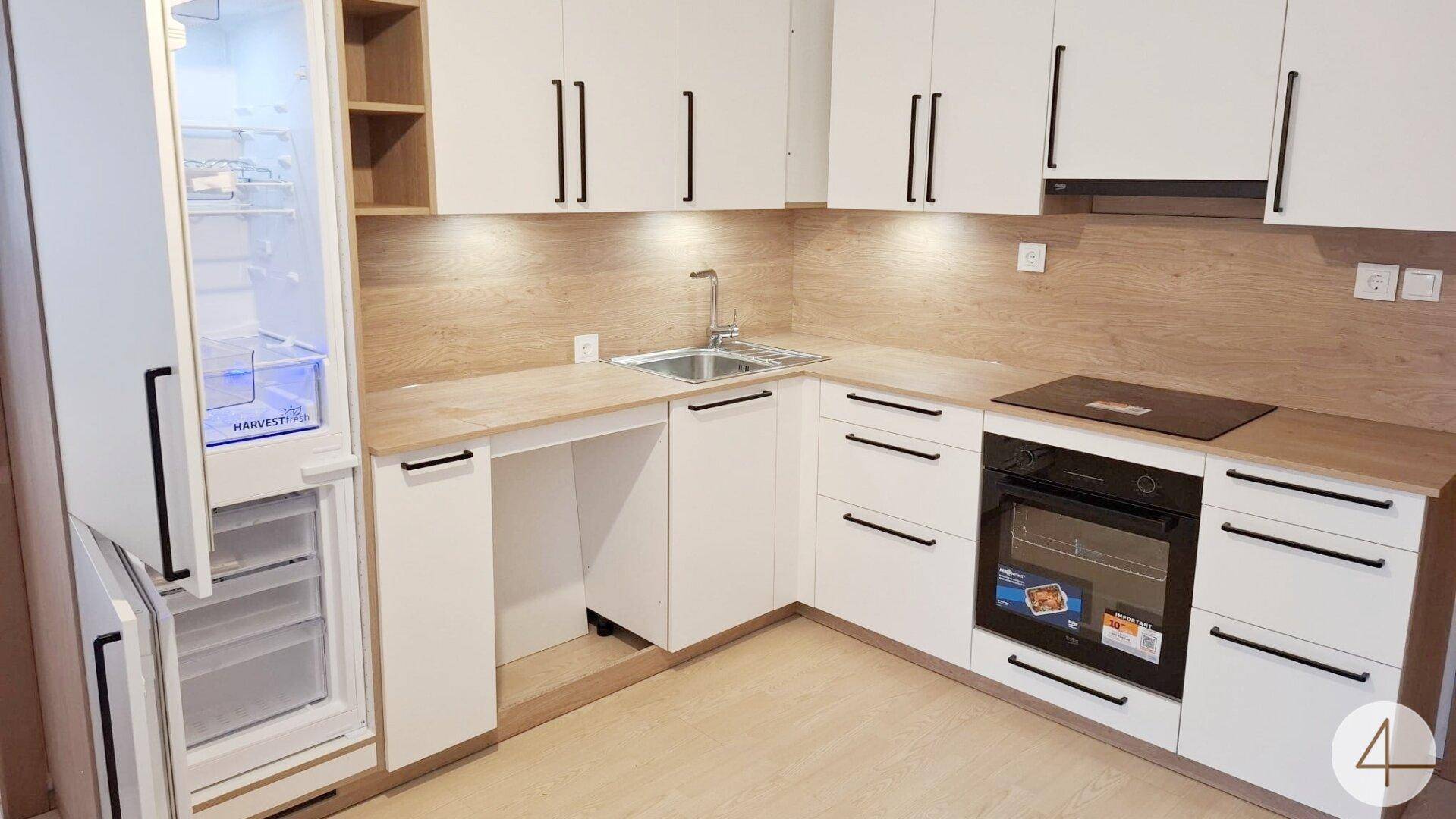 Helle, L-förmige Küche mit weißen Fronten, Holzdekor und neuem Einbauofen.