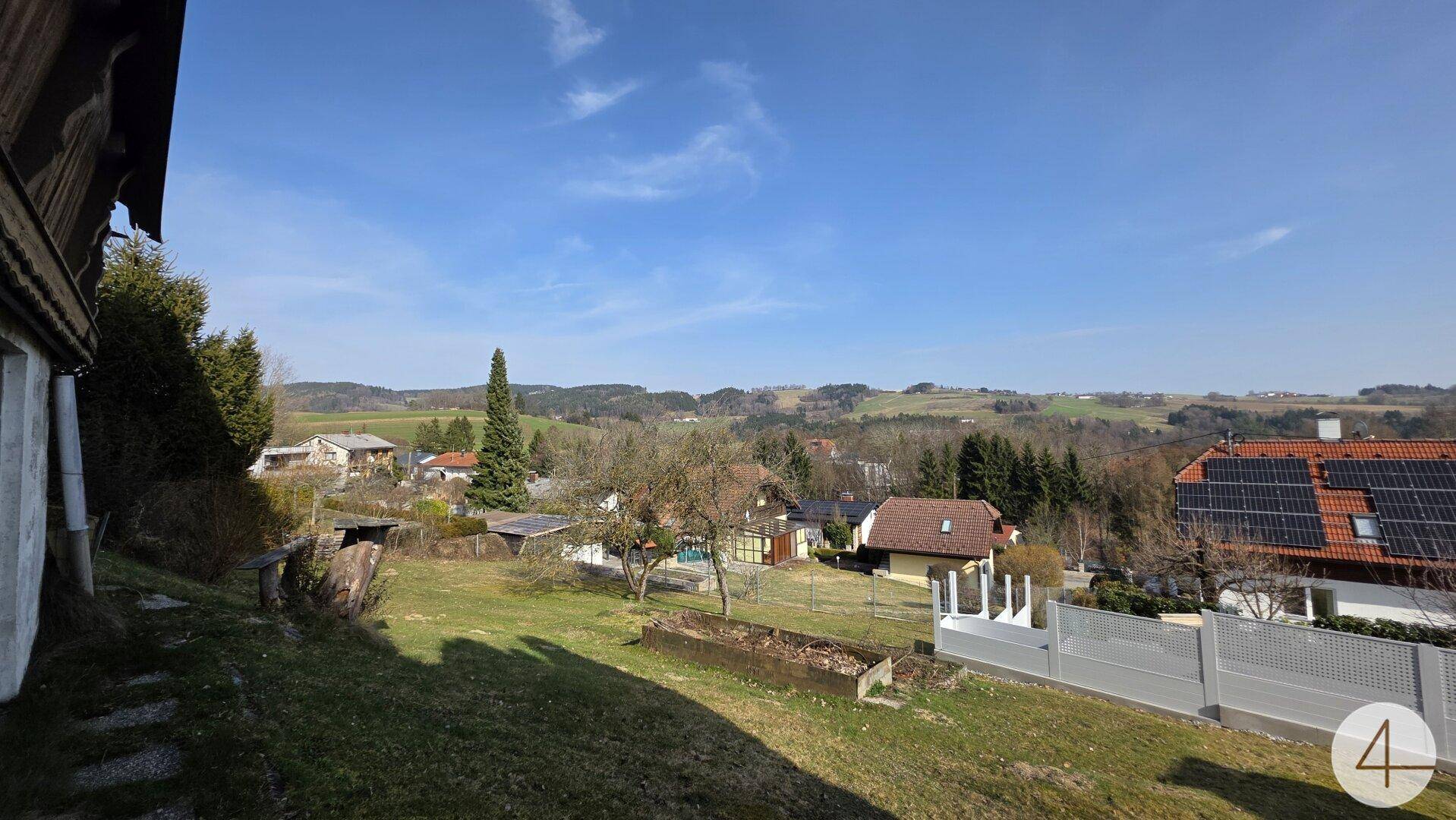 Weitläufige Aussicht auf die ländliche Umgebung mit benachbarten Häusern und Solaranlagen.