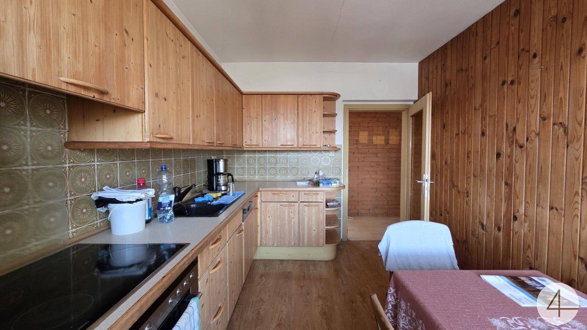 Traditionelle Küche mit Holzschränken, gefliestem Spritzschutz und einem kleinen Essbereich.