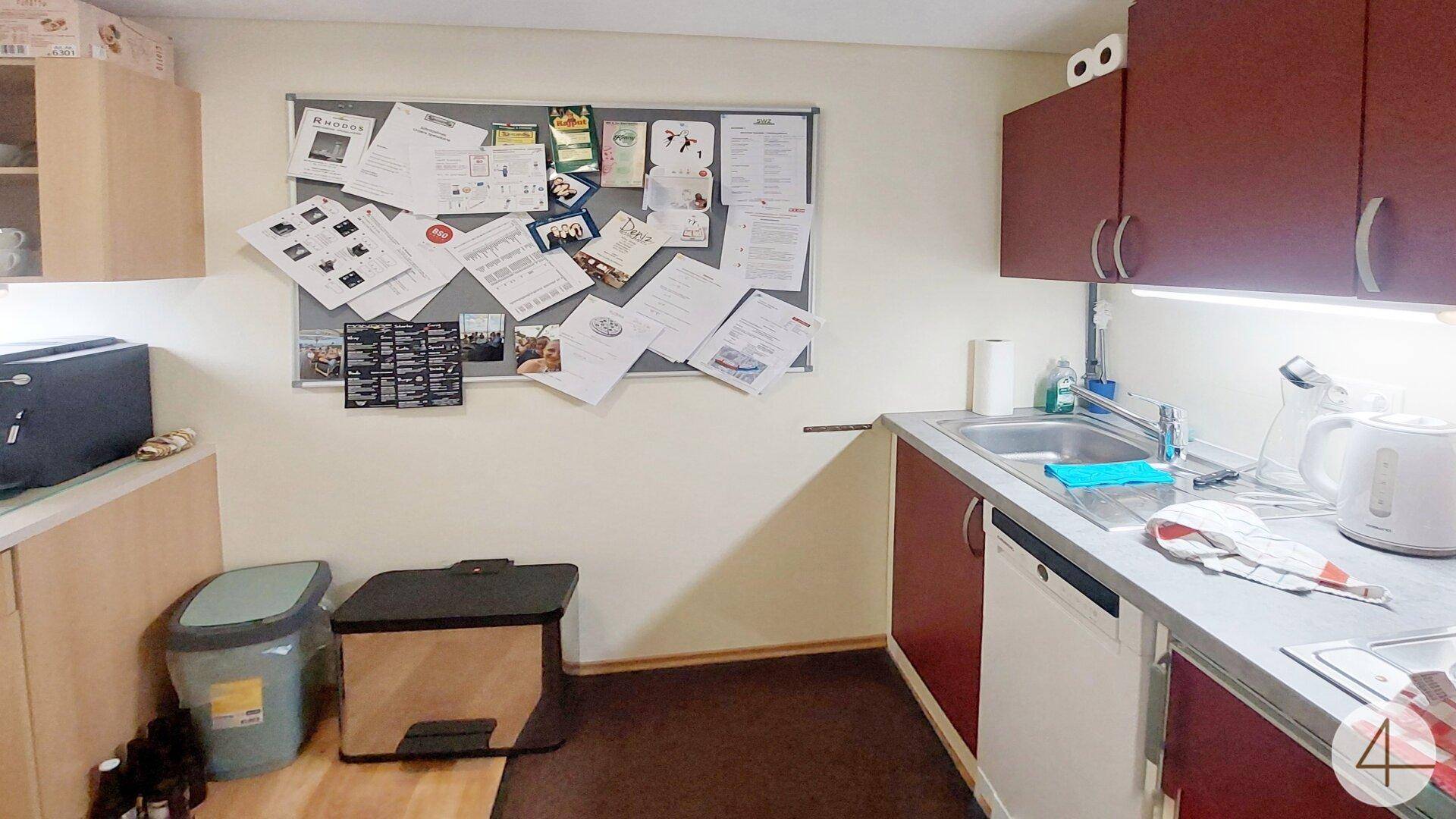 Funktionale Küchenzeile mit Spüle, Geschirrspüler und Stauraum, ideal für Pausen.