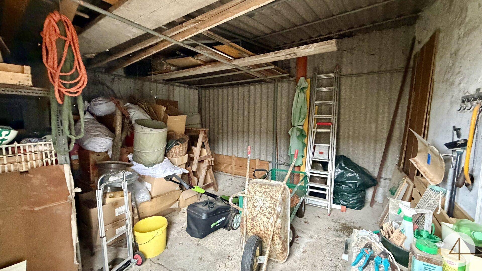 Innenansicht einer Garage oder eines Abstellschuppens mit Werkzeugen und Geräten.