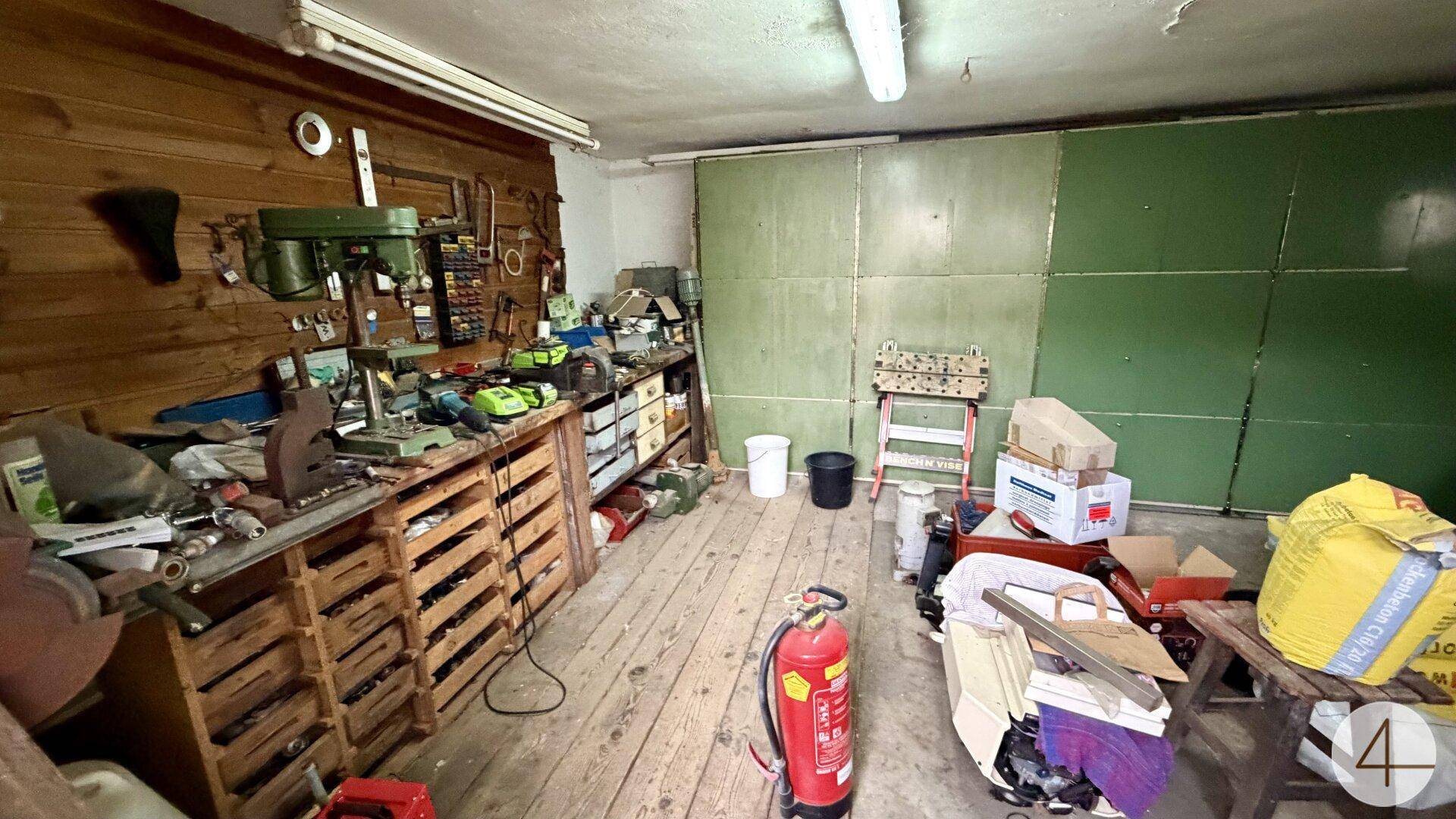 Innenansicht einer Werkstatt mit Holzwänden und zahlreichen Werkzeugen.