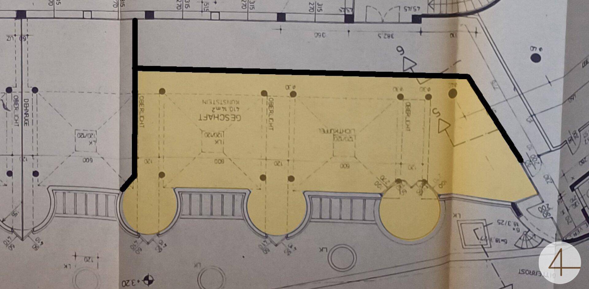 Grundrissplan eines Geschäftsraums mit markierten Flächen und strukturellen Details.