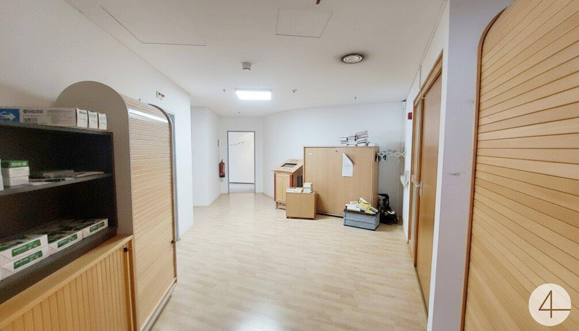 Geräumiger Flur mit Holzfußboden und integrierten Holzschränken, der zu weiteren Bereichen führt.