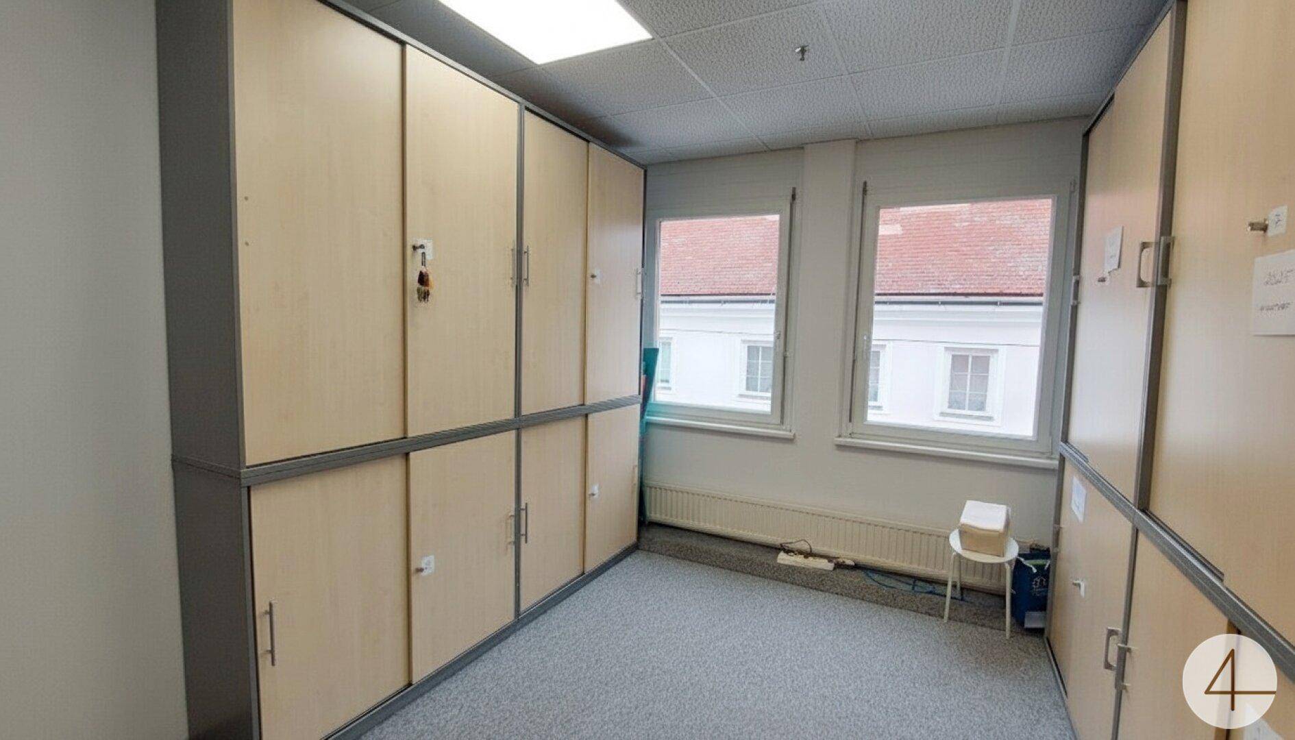 Praktischer Lagerraum mit zahlreichen Schränken und Fenstern, die für Belüftung sorgen.