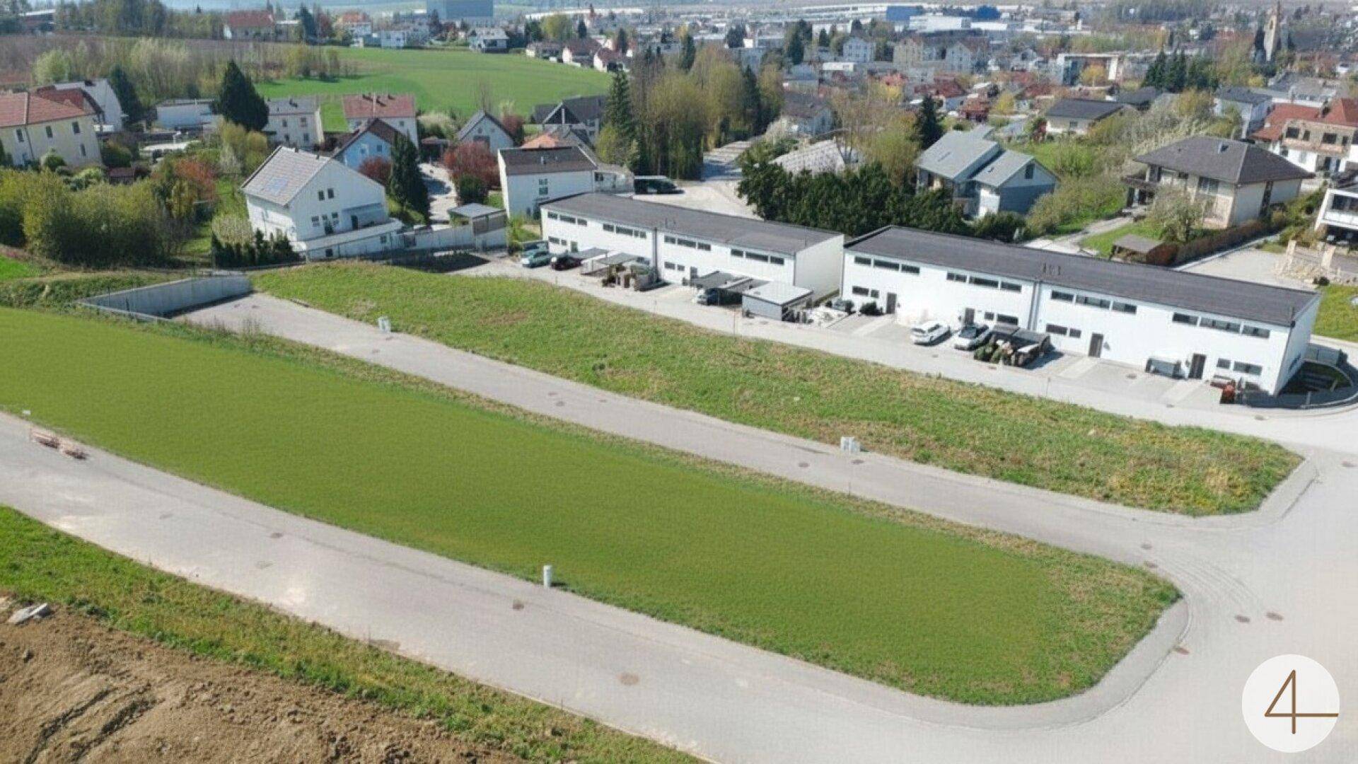 Luftaufnahme eines Wohngebiets mit mehreren Reihenhäusern und unbebauten Parzellen.