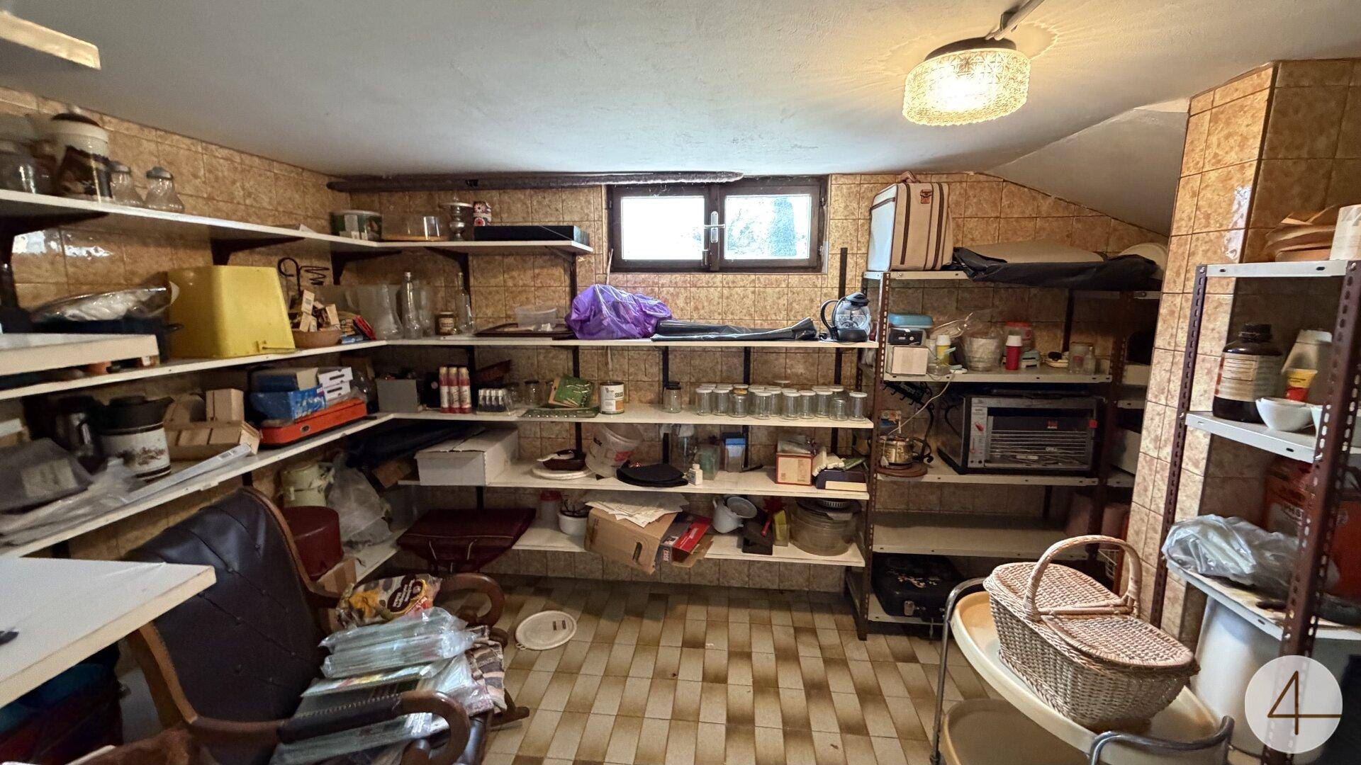 Geräumiger Kellerraum mit vielen Regalen für Lagerung und einem kleinen Fenster.