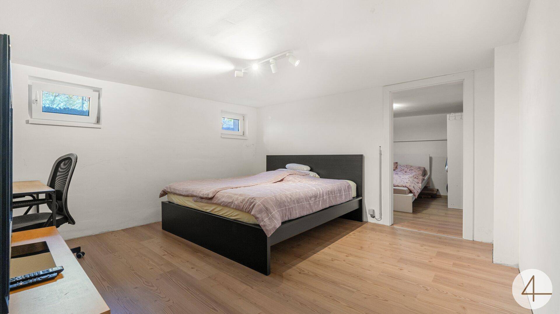 Schlafzimmer im Untergeschoss mit zwei Betten und kleinen Fenstern.