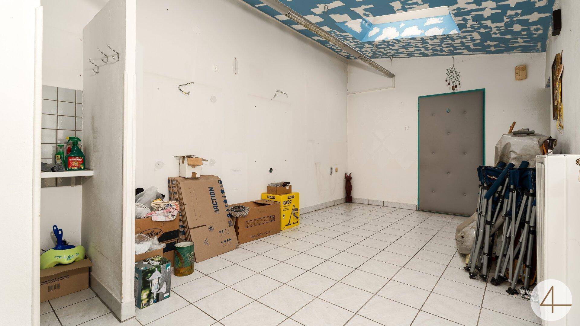 Geräumiger Abstellraum mit Fliesenboden, weiß gestrichenen Wänden und einer dekorativen Decke.