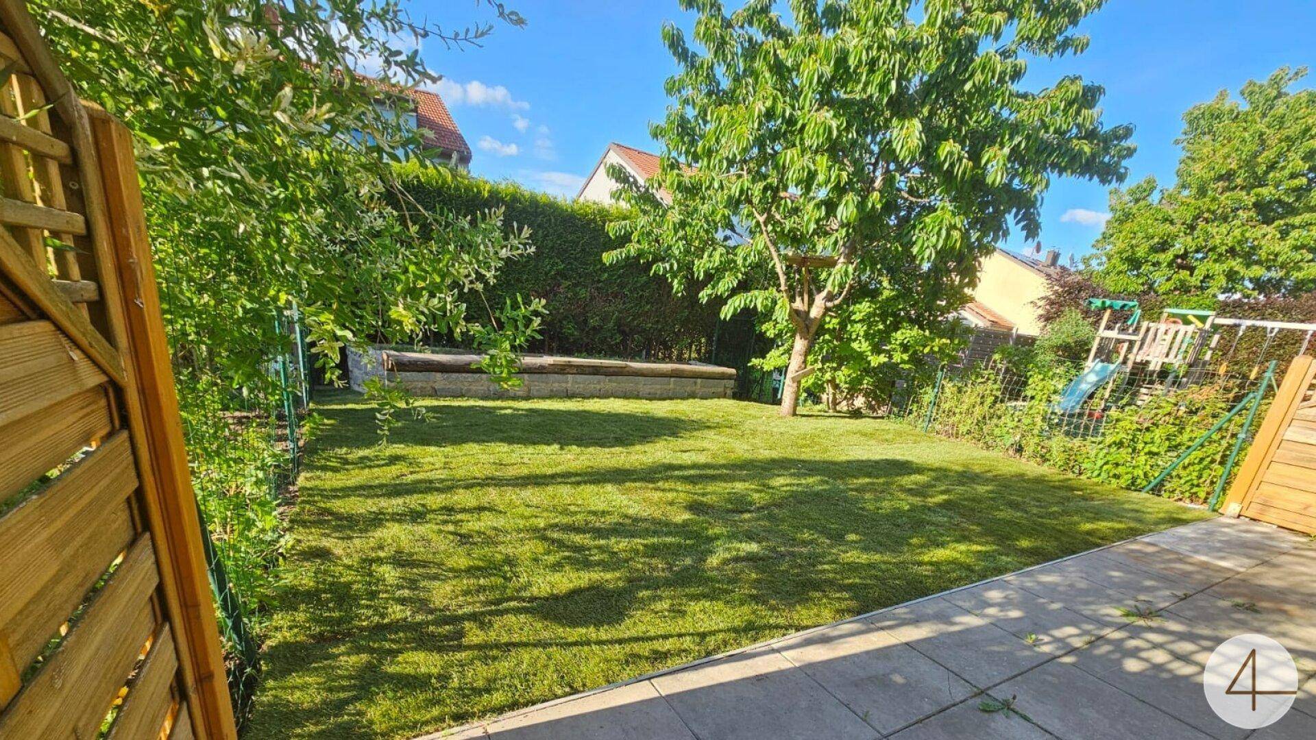 Sonniger Garten mit frisch gemähtem Rasen, umgeben von grünen Hecken und Bäumen, perfekt für Freizeit.