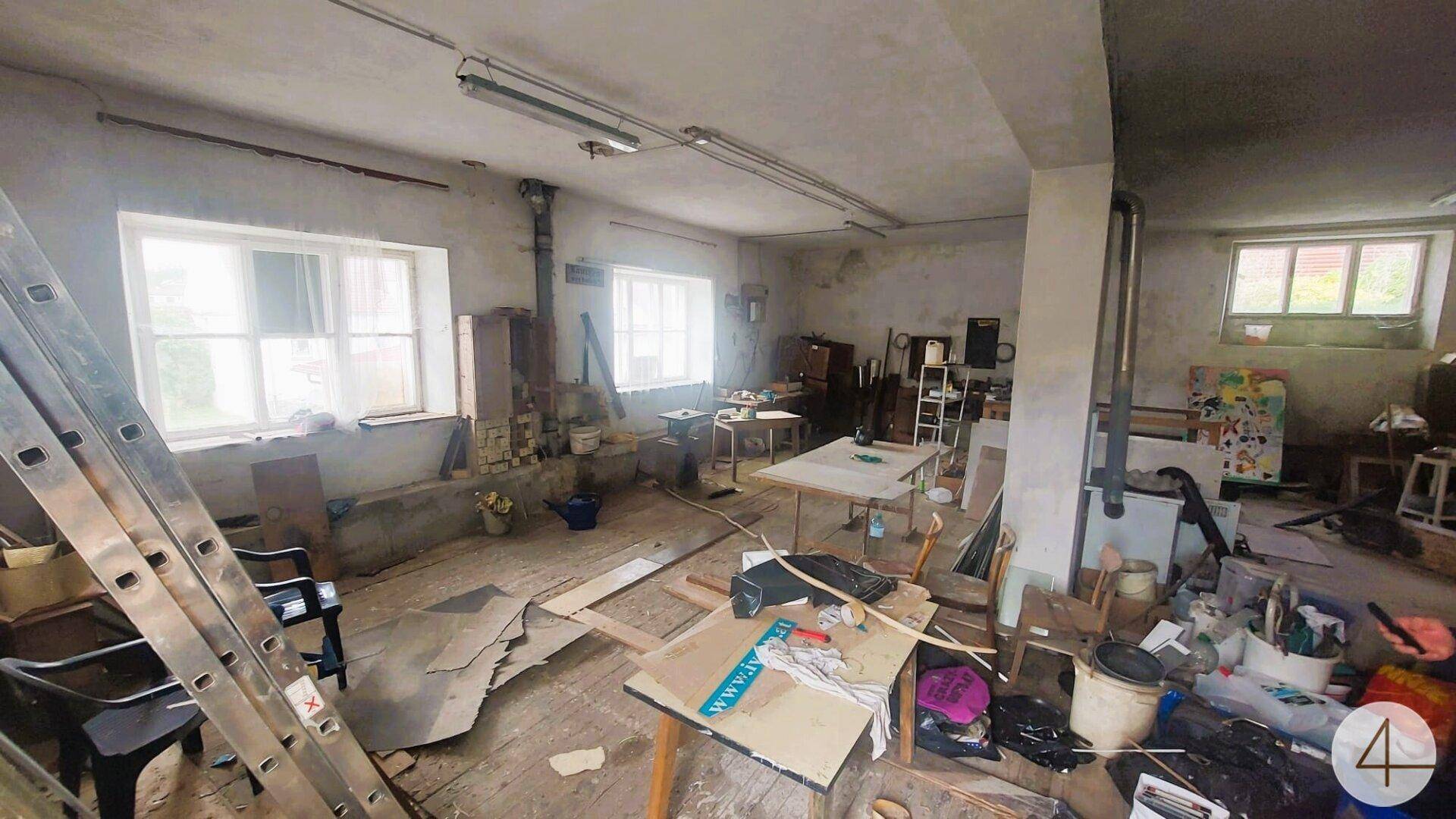 Großer, unaufgeräumter Raum mit Werkbänken, Fenstern und viel Stauraum, ideal als Werkstatt.