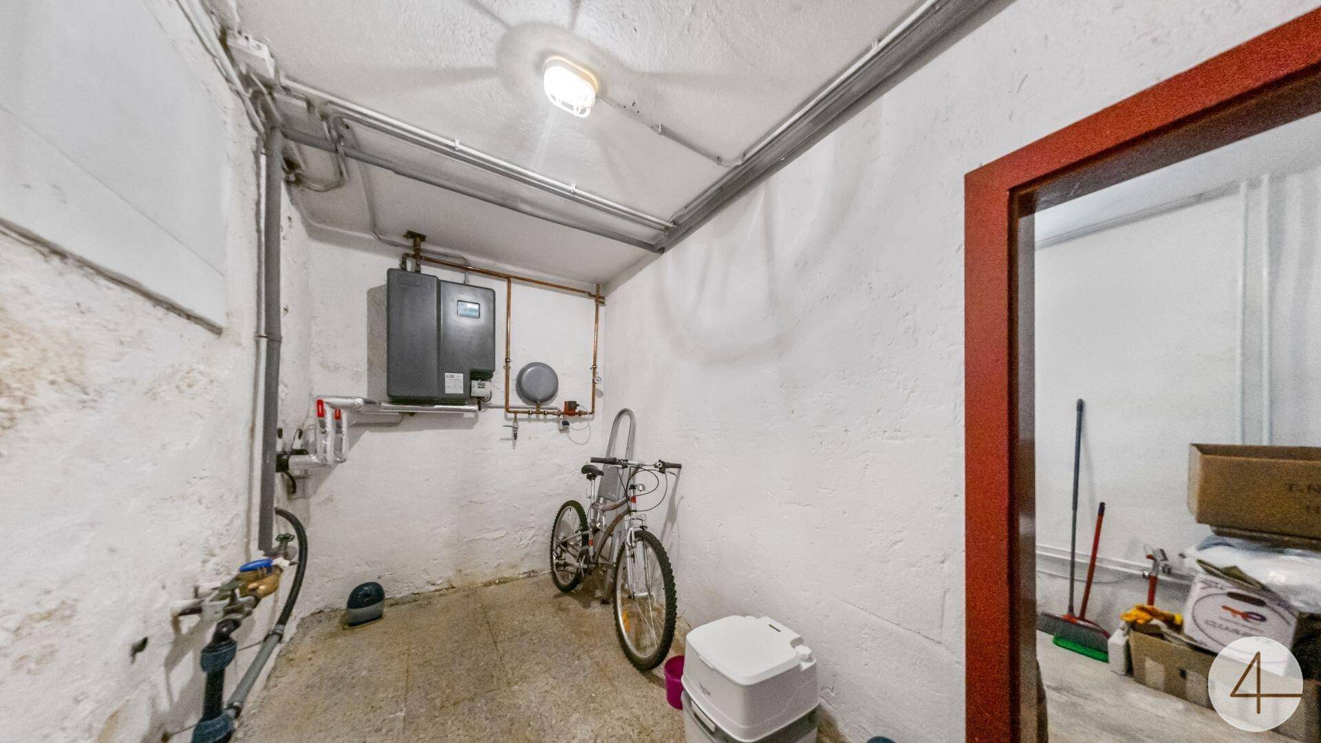 Hauswirtschaftsraum im Keller mit Warmwasserbereiter, sichtbaren Leitungen und Abstellmöglichkeiten.
