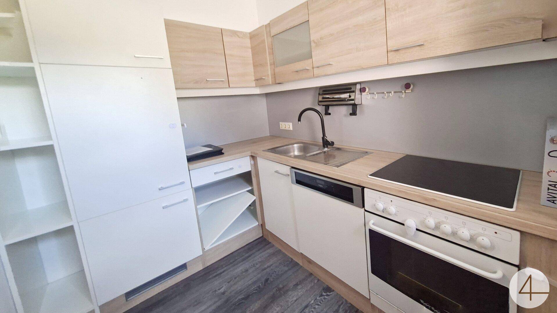 Kompakte Küche mit Holzoptik-Arbeitsplatte, integrierten Geräten und ausreichend Stauraum.