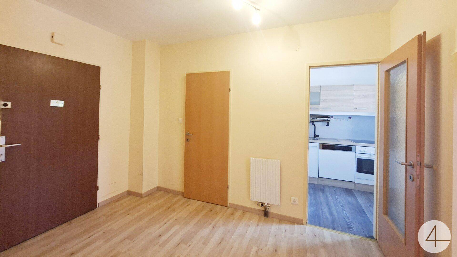 Eingangsbereich mit Laminatboden und Zugang zur Küche sowie weiteren Räumen.