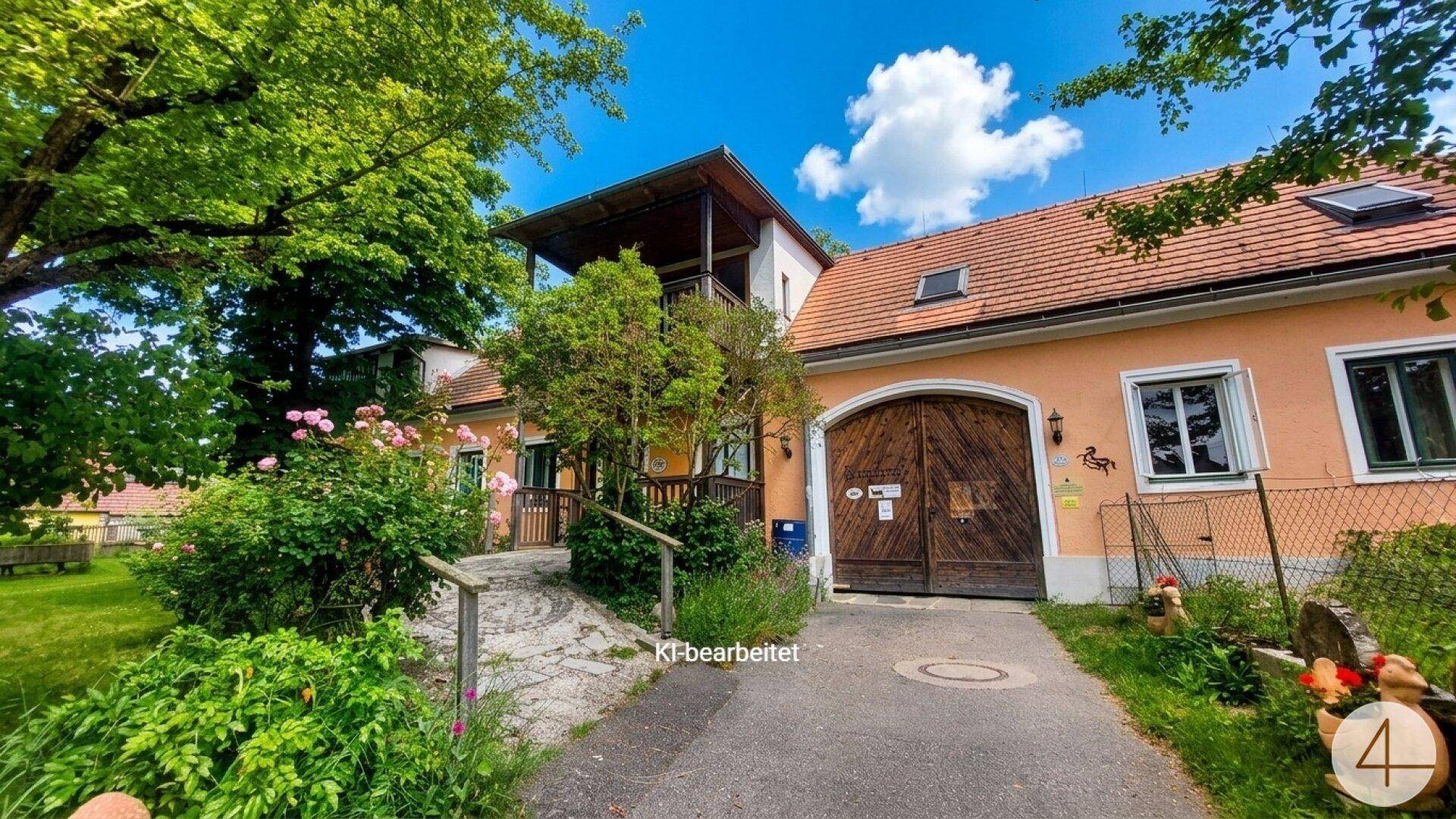 Das charmante Landhaus mit seiner Einfahrt und dem üppigen Garten, unter einem strahlend blauen Himmel.