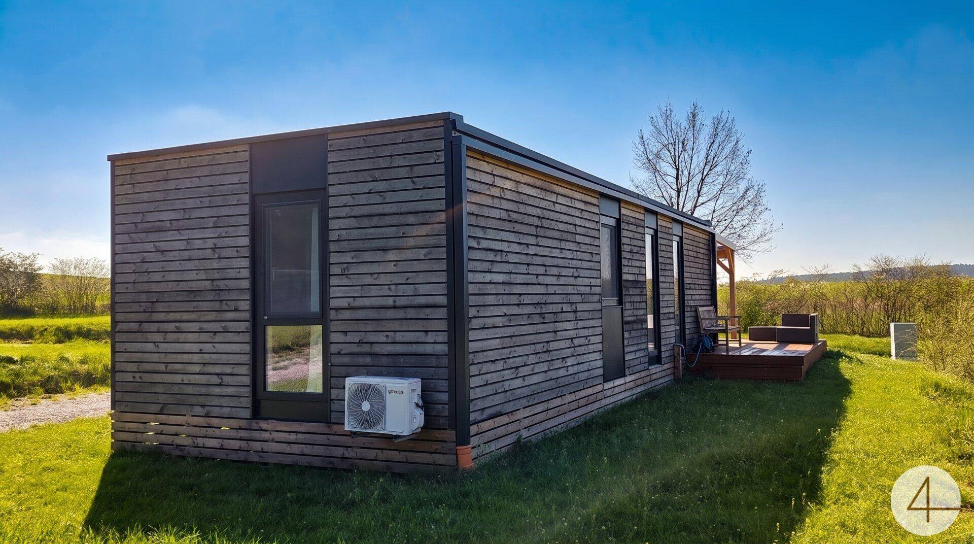 Seitenansicht des modernen Modulhauses mit Holzverkleidung und Klimaanlage an der Fassade.