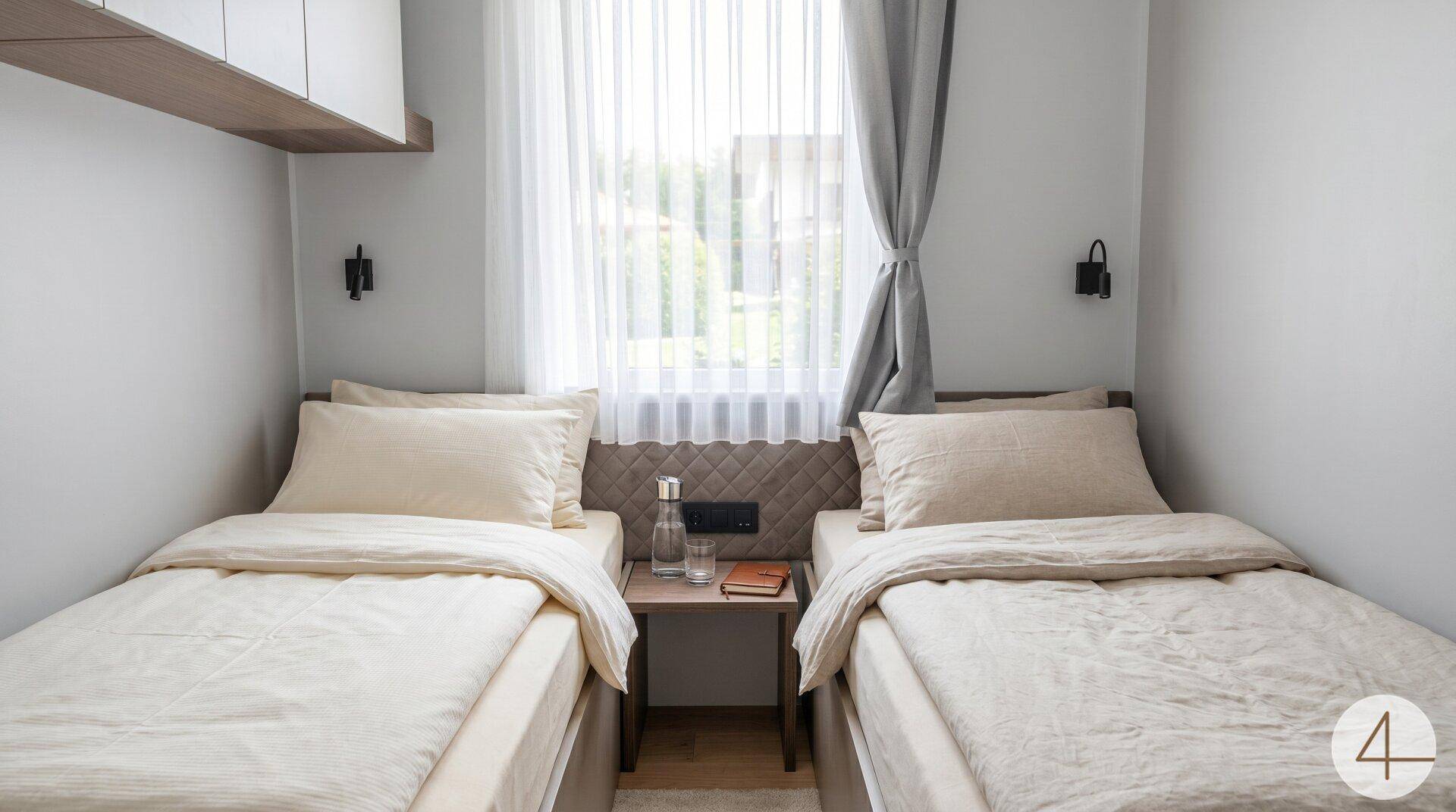 Helles Schlafzimmer mit zwei Einzelbetten, Fenster und schlichter, moderner Einrichtung.