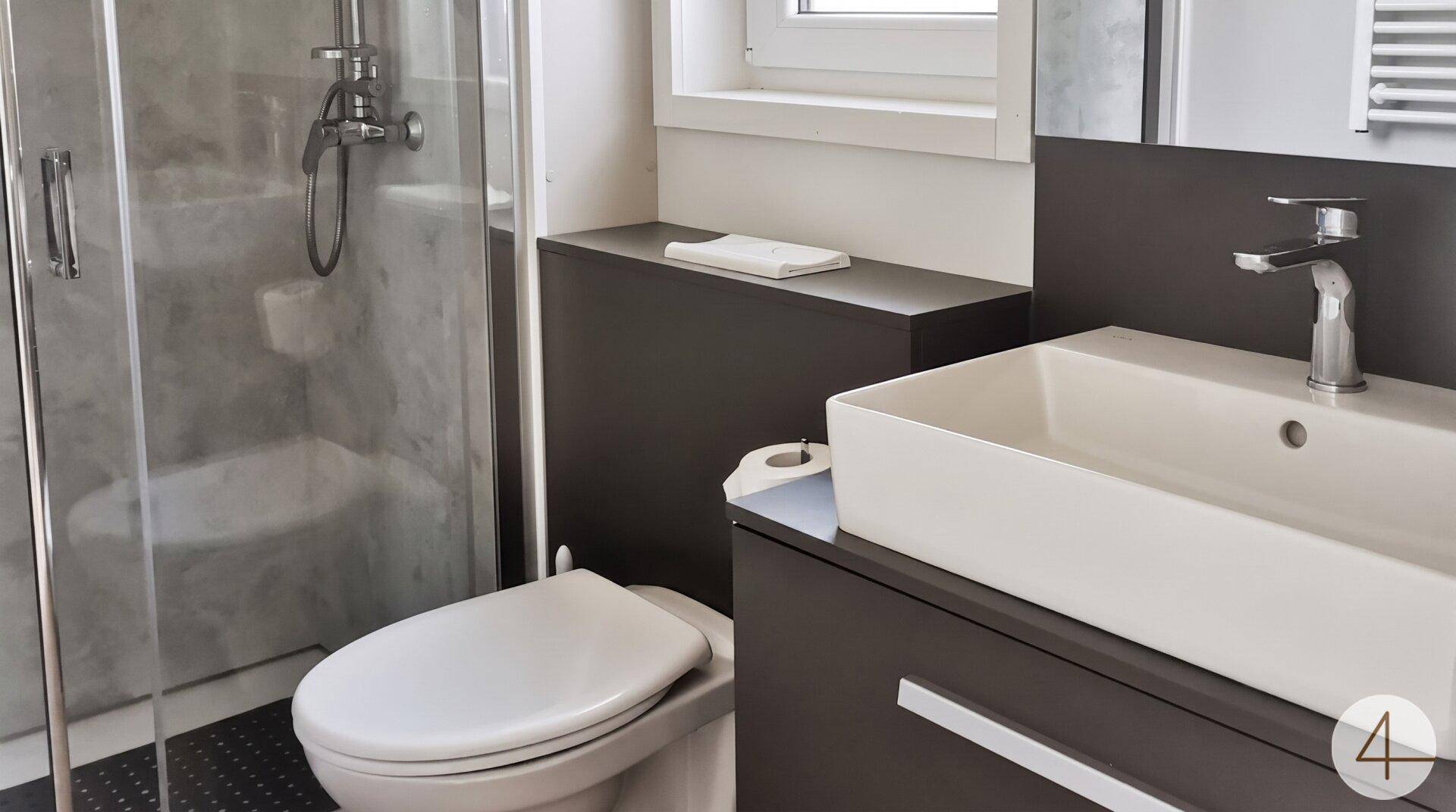 Modernes Badezimmer mit Duschkabine, Toilette und elegantem Einzelwaschbecken.