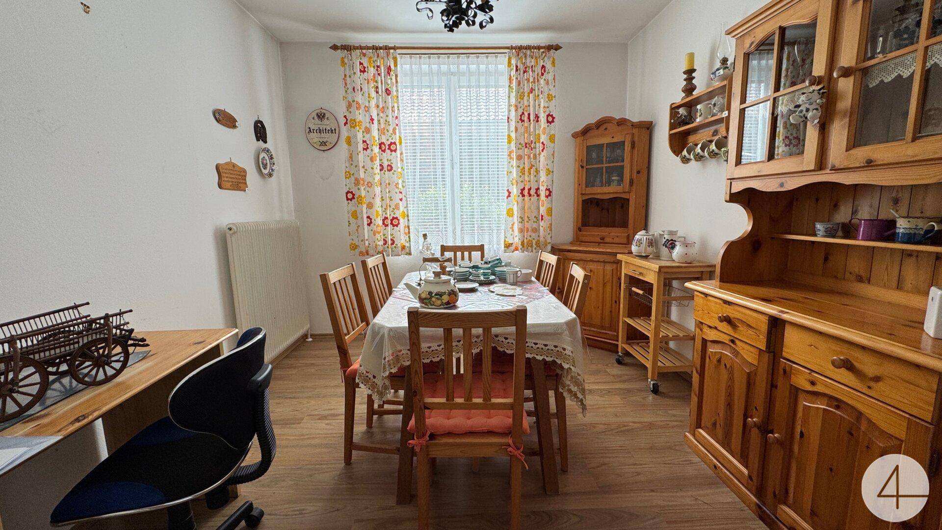 Traditioneller Essbereich mit Holztisch, Stühlen und passenden Holzschränken, ideal für Familienessen.