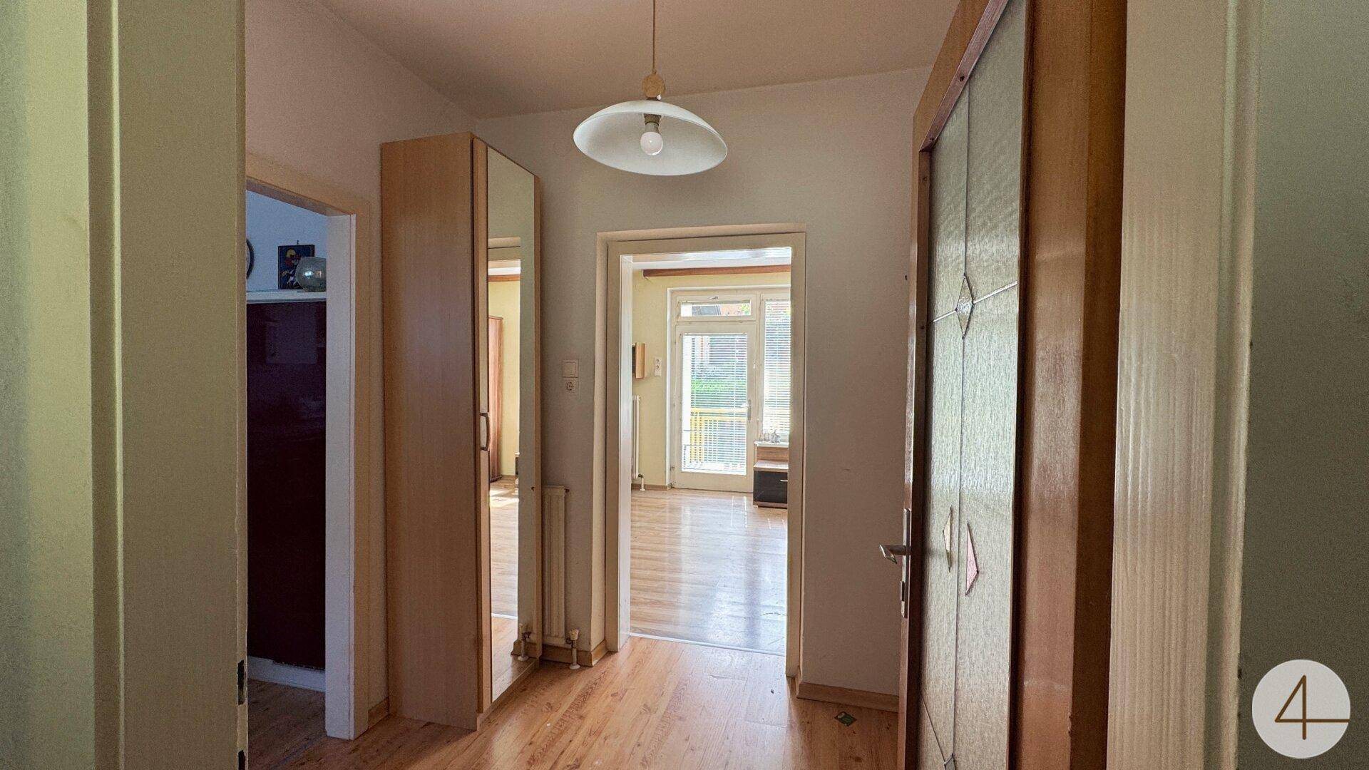 Heller Flur mit Laminatboden, der zu den verschiedenen Räumen des Hauses führt.