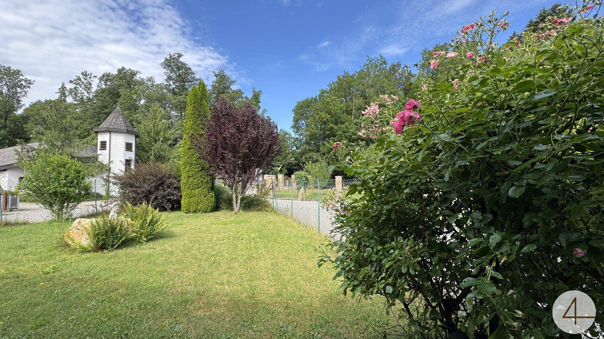 Weitläufiger Gartenbereich mit Rasenflächen, Bäumen und Sträuchern, ideal zum Entspannen im Freien.