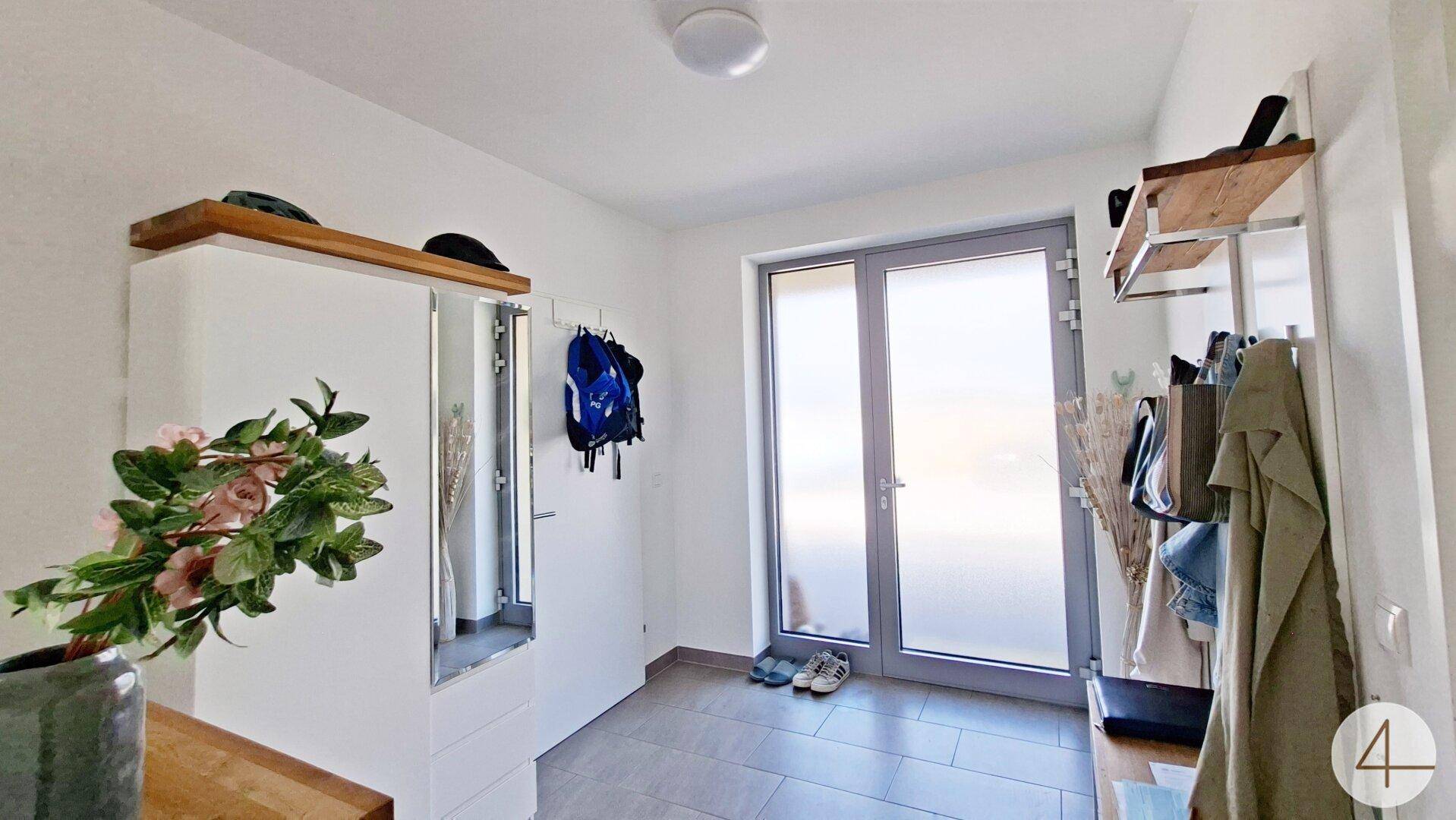 Eingangsbereich mit Fliesenboden, Garderobe und Spiegelschrank.