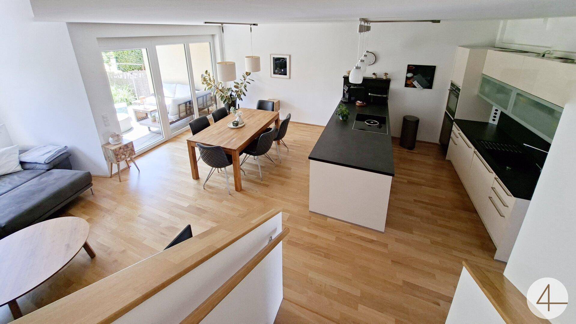 Geräumiger offener Wohnbereich mit Küche, Essbereich und Zugang zur Terrasse.