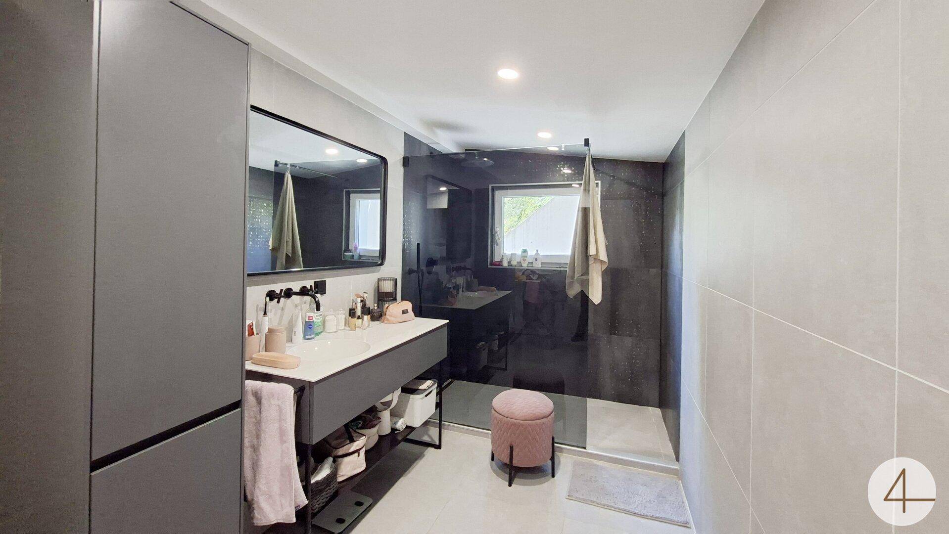 Modernes Badezimmer mit großer begehbarer Dusche, Einzelwaschbecken und Fenster.