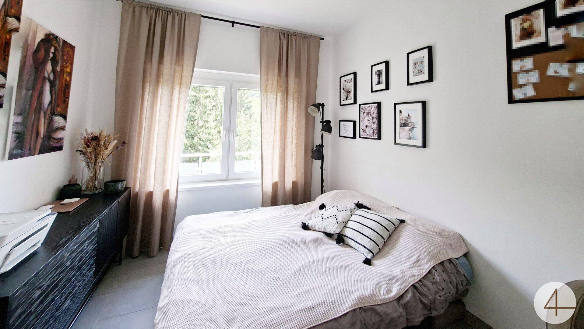 Schlafzimmer mit Doppelbett, Fenster und moderner Dekoration, hell und einladend.