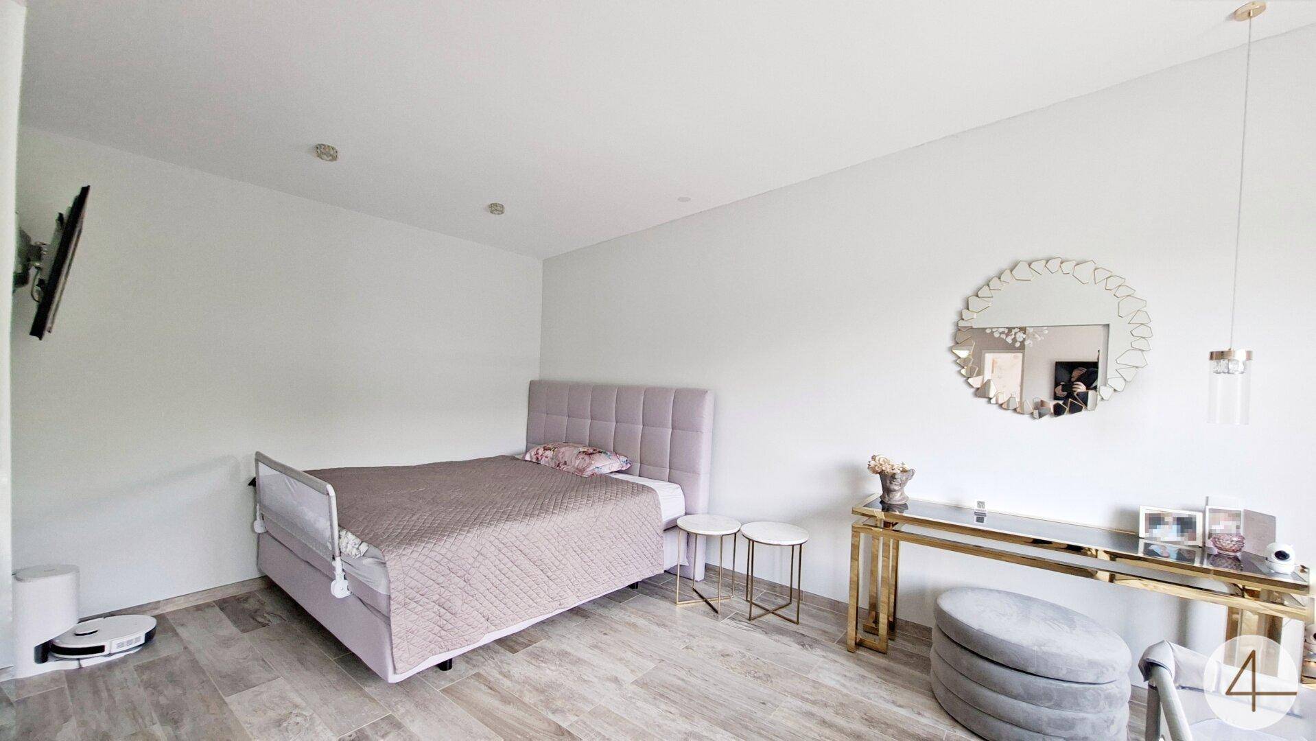 Helles Schlafzimmer mit Einzelbett, Schminktisch und Spiegel, modern eingerichtet.