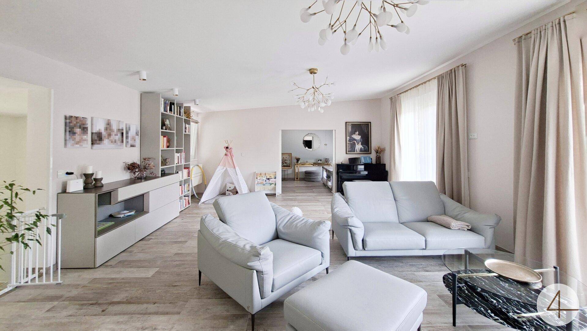 Helles Wohnzimmer mit modernem Interieur, bequemen Sofas und Holzbodenoptik.