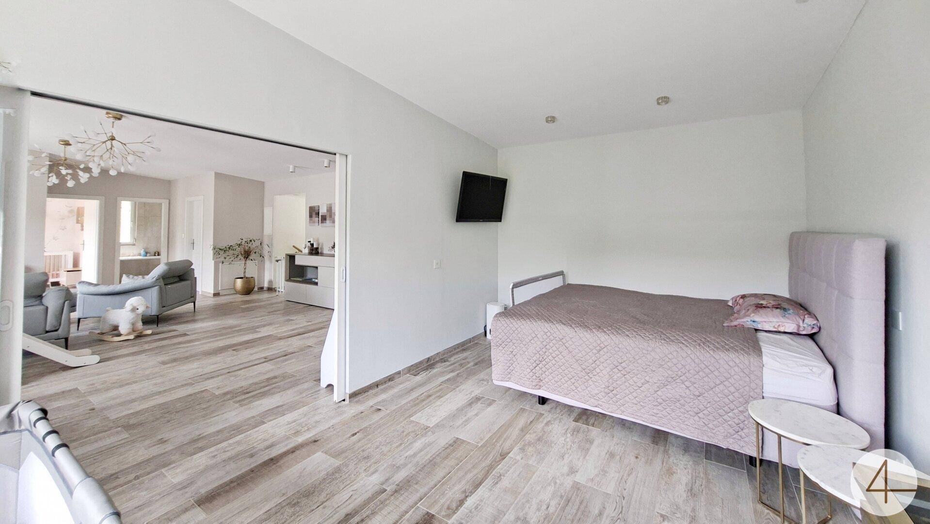 Schlafzimmer mit Blick in den angrenzenden Wohnbereich, hell und offen gestaltet.