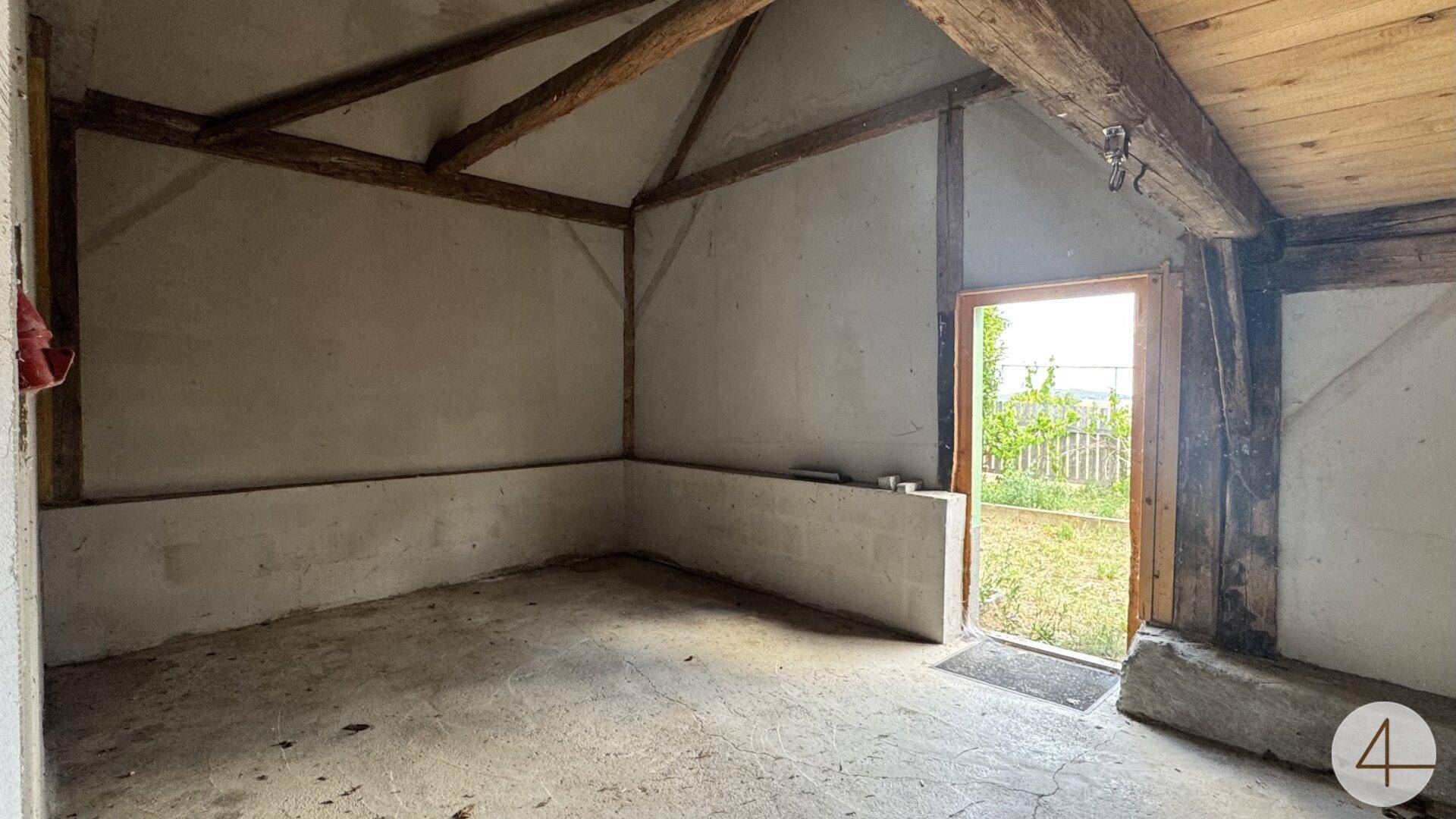 Unfertiger Raum mit Holzbalken und Ausgang zum Garten, ideal für zukünftige Gestaltung.