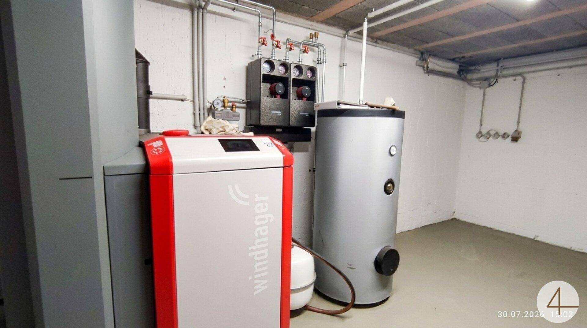 Technikraum mit moderner Heizungsanlage und Warmwasserspeicher, sauber und funktional.