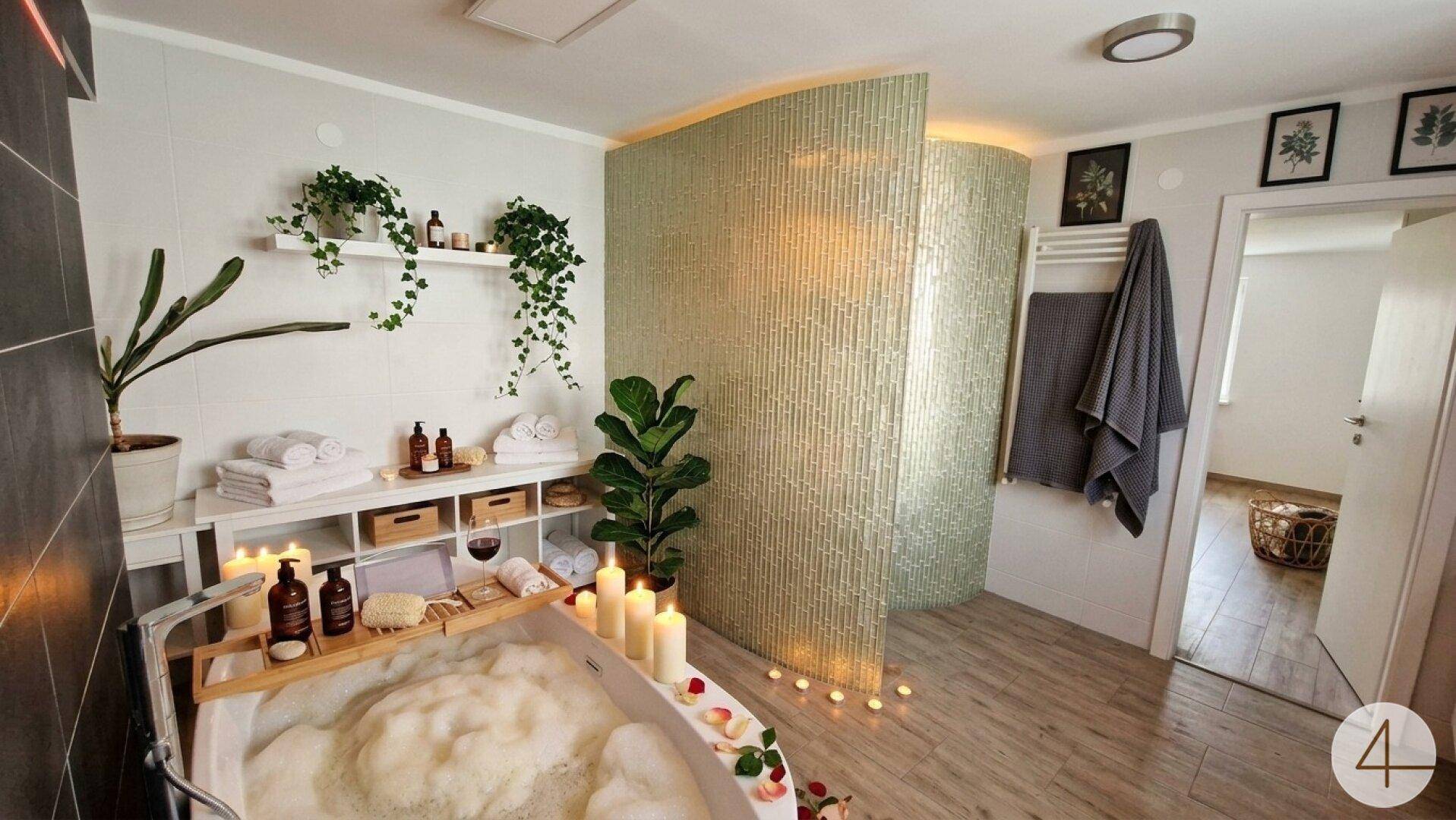 Luxuriöses Badezimmer mit freistehender Badewanne, Kerzen und Wellness-Atmosphäre.