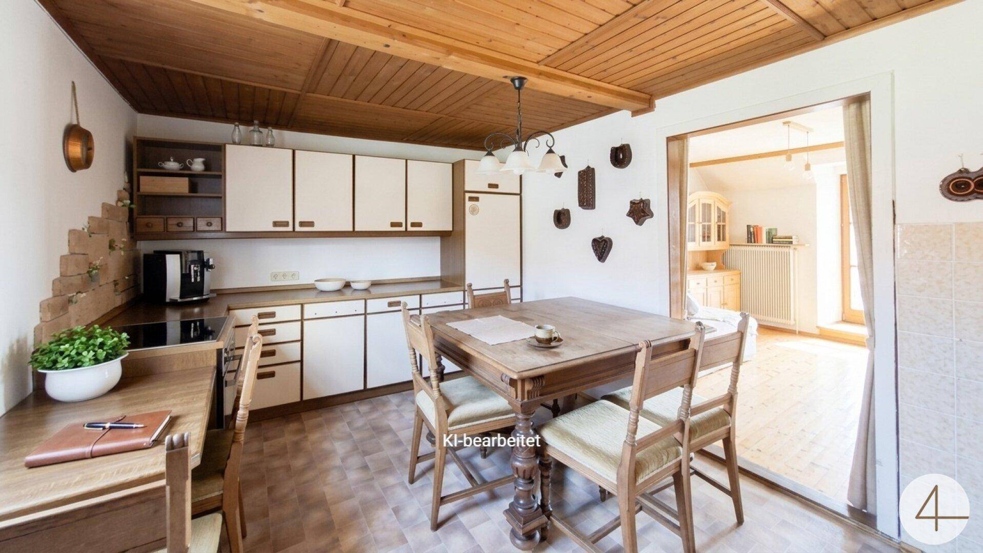 Traditionelle Küche mit Essbereich, Holzdecke und hellen Einbauschränken.