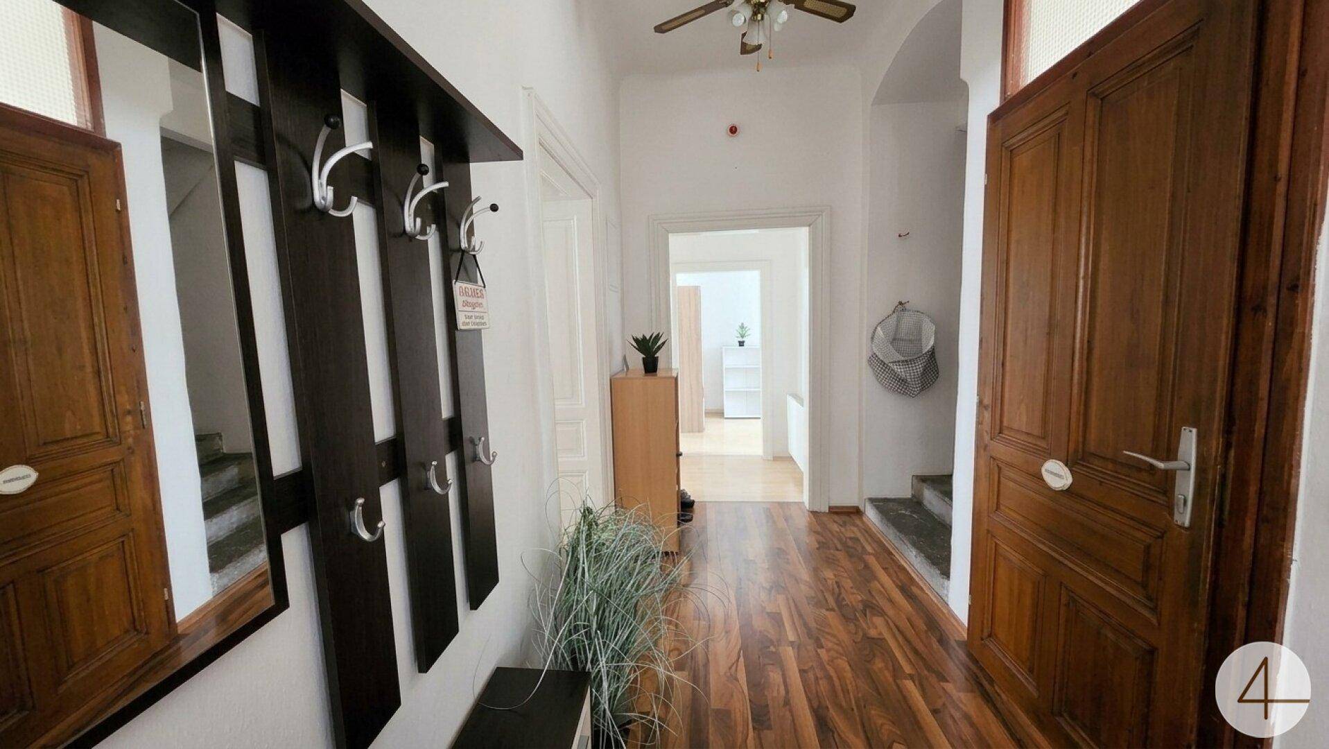 Geräumiger Flur mit Holzboden, Garderobe und Zugang zu verschiedenen Zimmern.