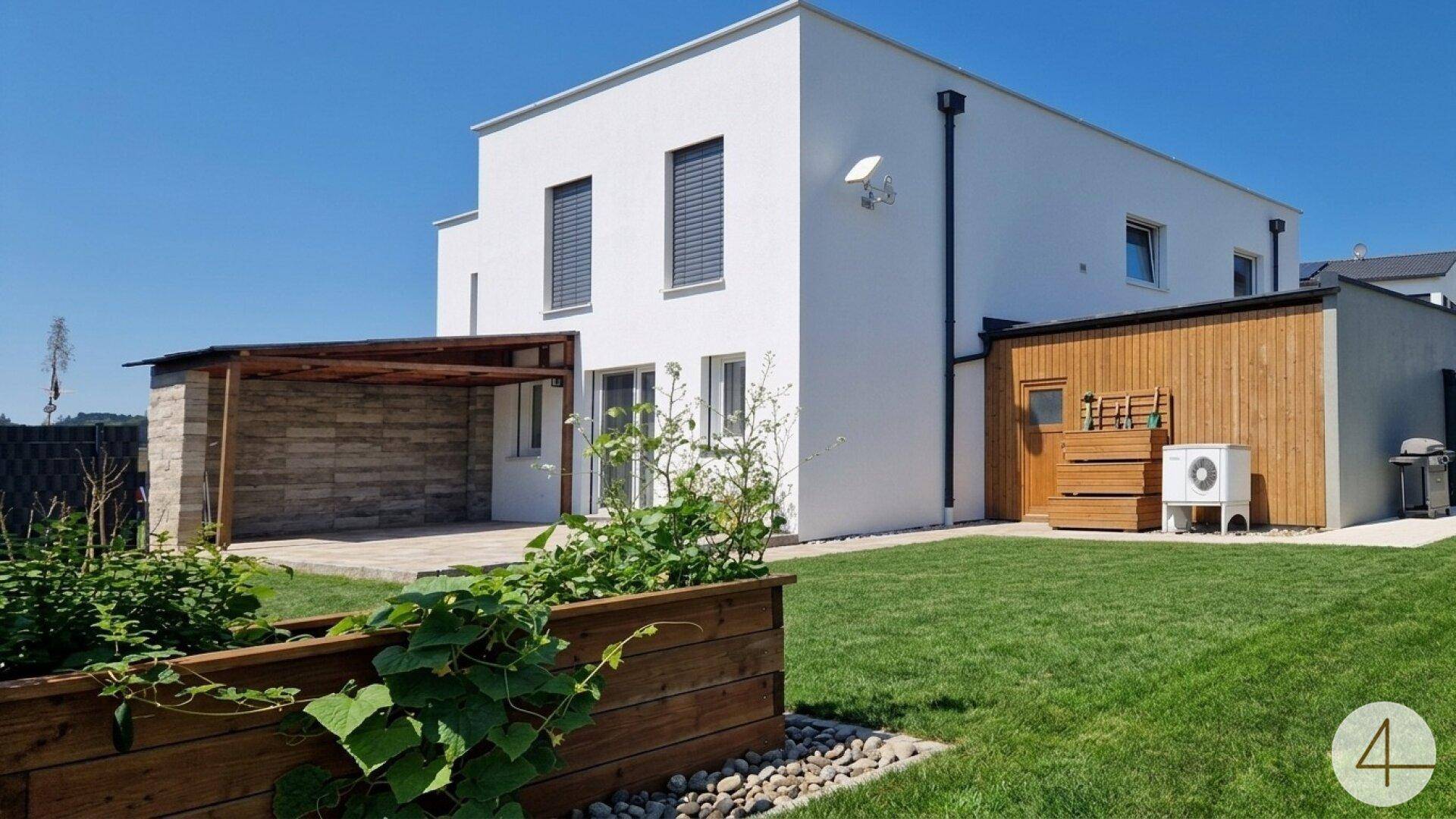Neubau-Einfamilienhaus mit gepflegtem Garten, überdachter Terrasse und moderner Architektur an einem sonnigen Tag.