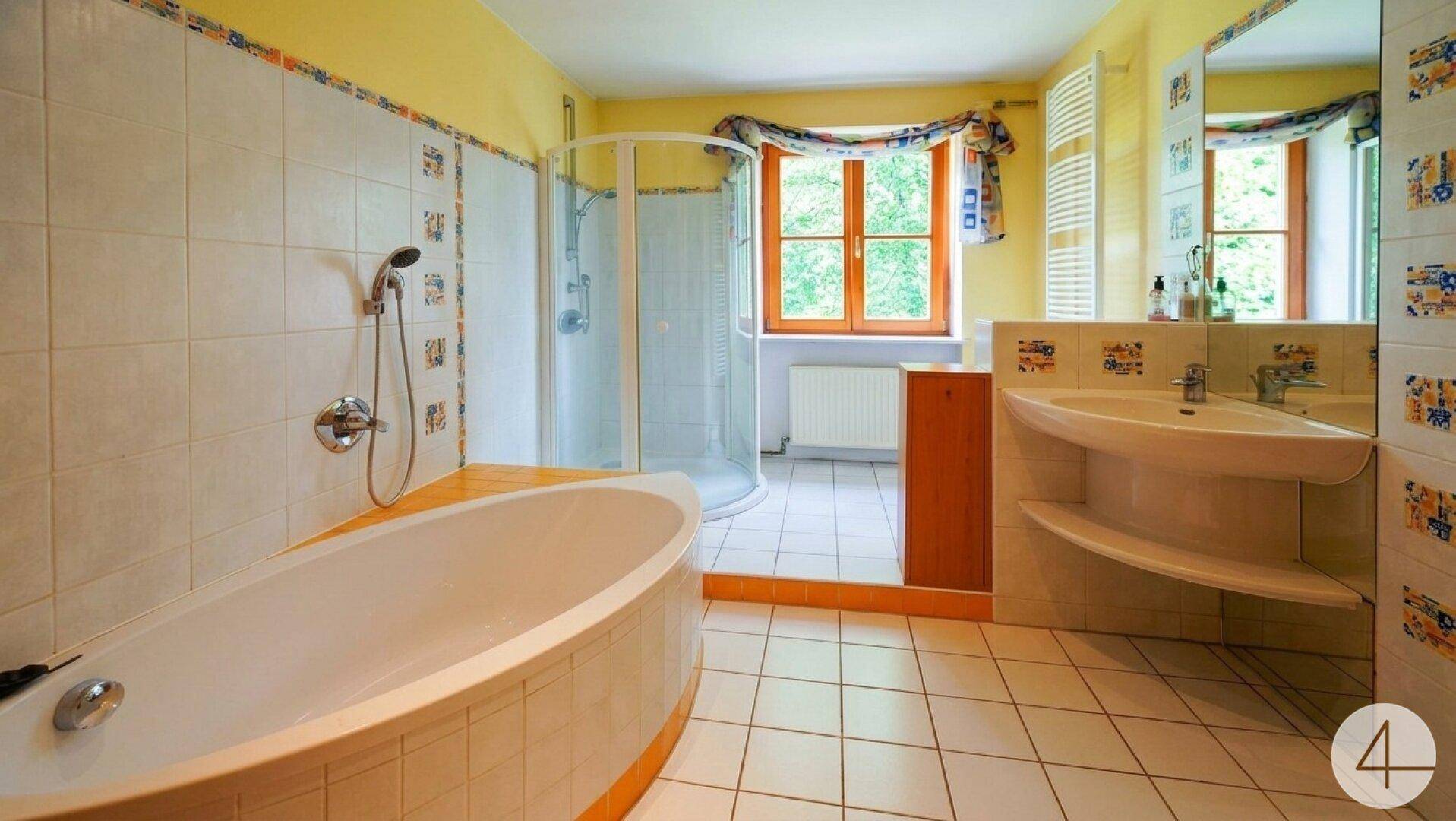 Geräumiges Badezimmer mit Badewanne, Duschkabine und farbigen Fliesen.